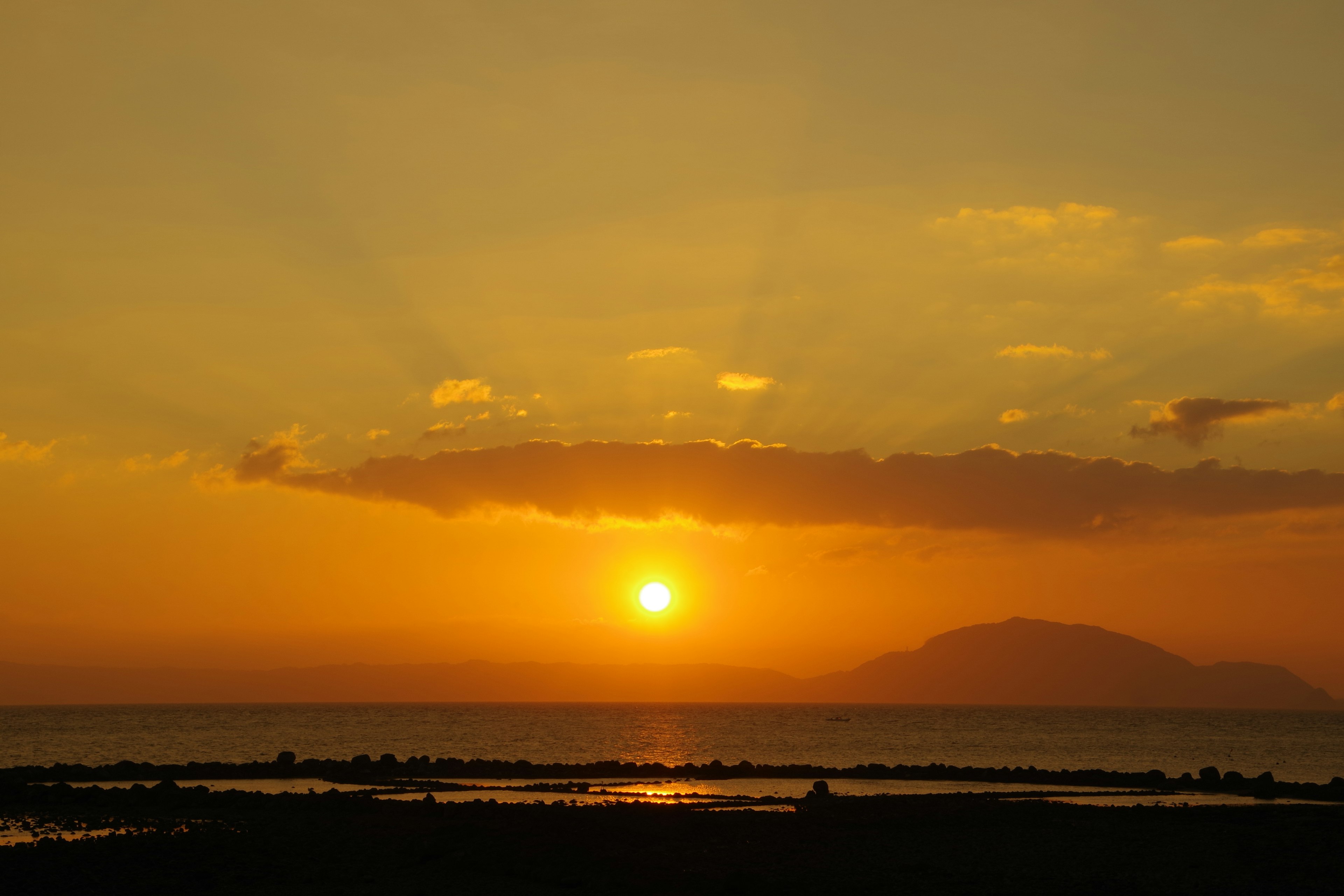 Un bellissimo tramonto sull'oceano con tonalità arancioni