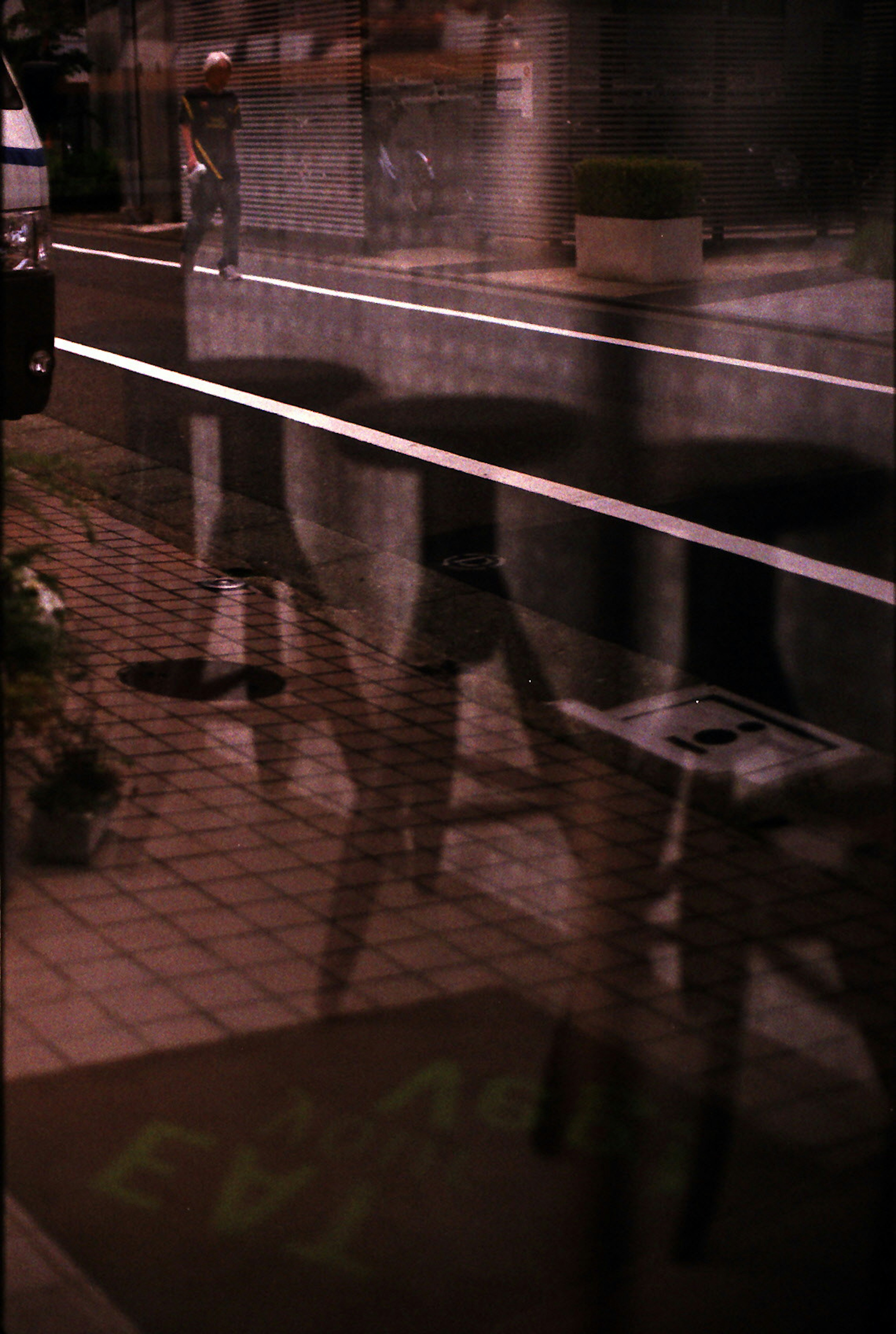 Nighttime street scene with reflections of chairs