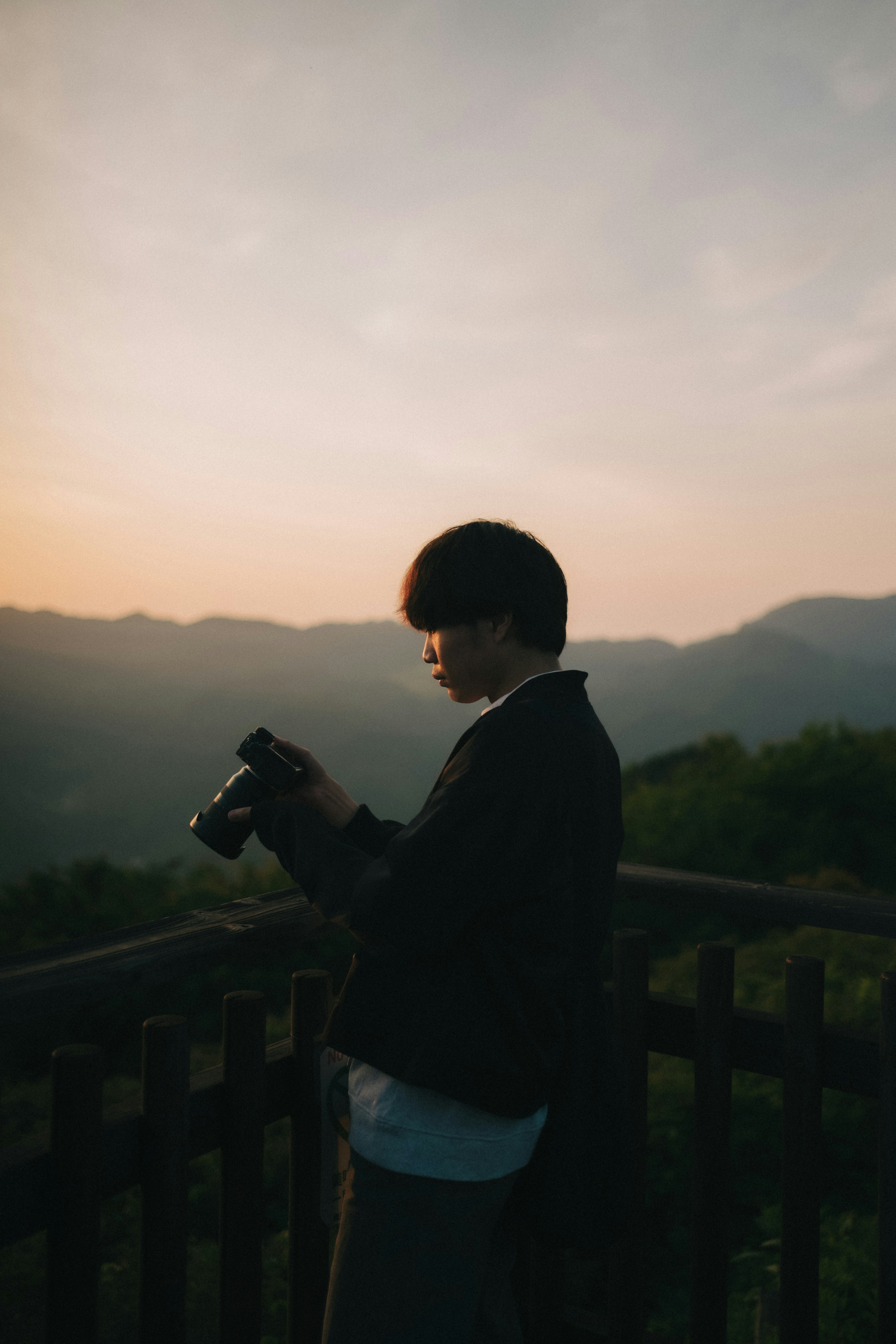 夕陽背景下拿著相機的人物剪影