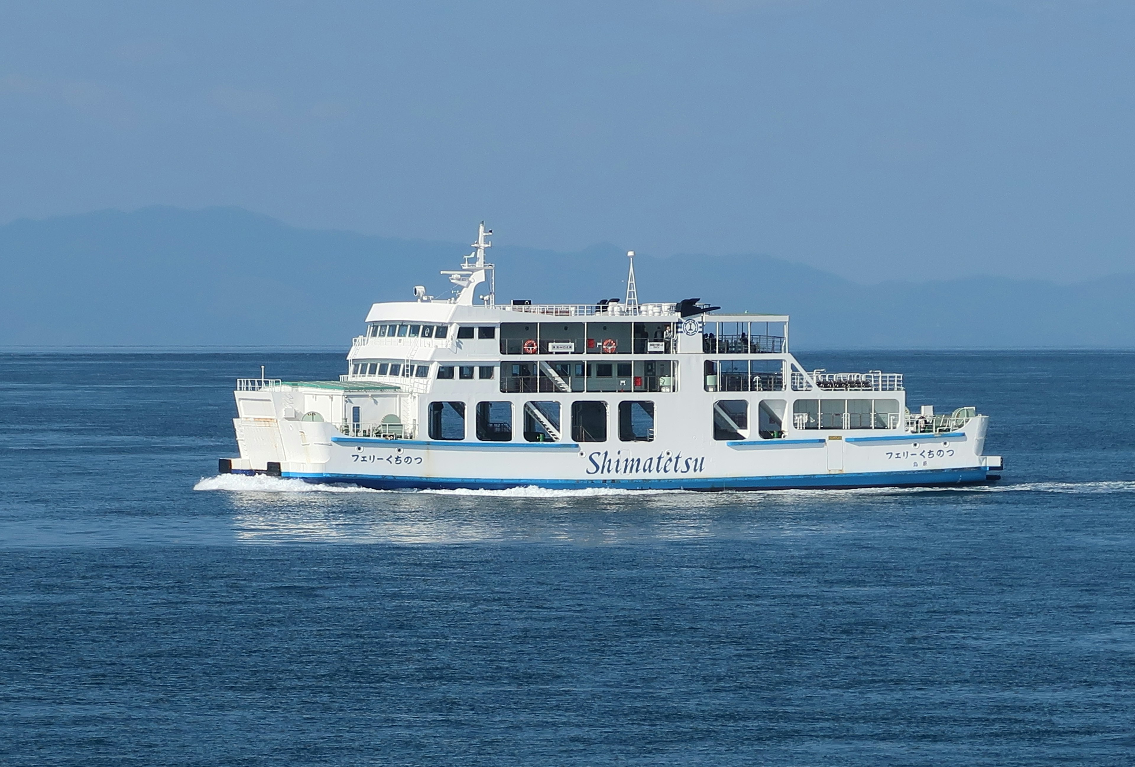 A white ferry sailing on a blue sea