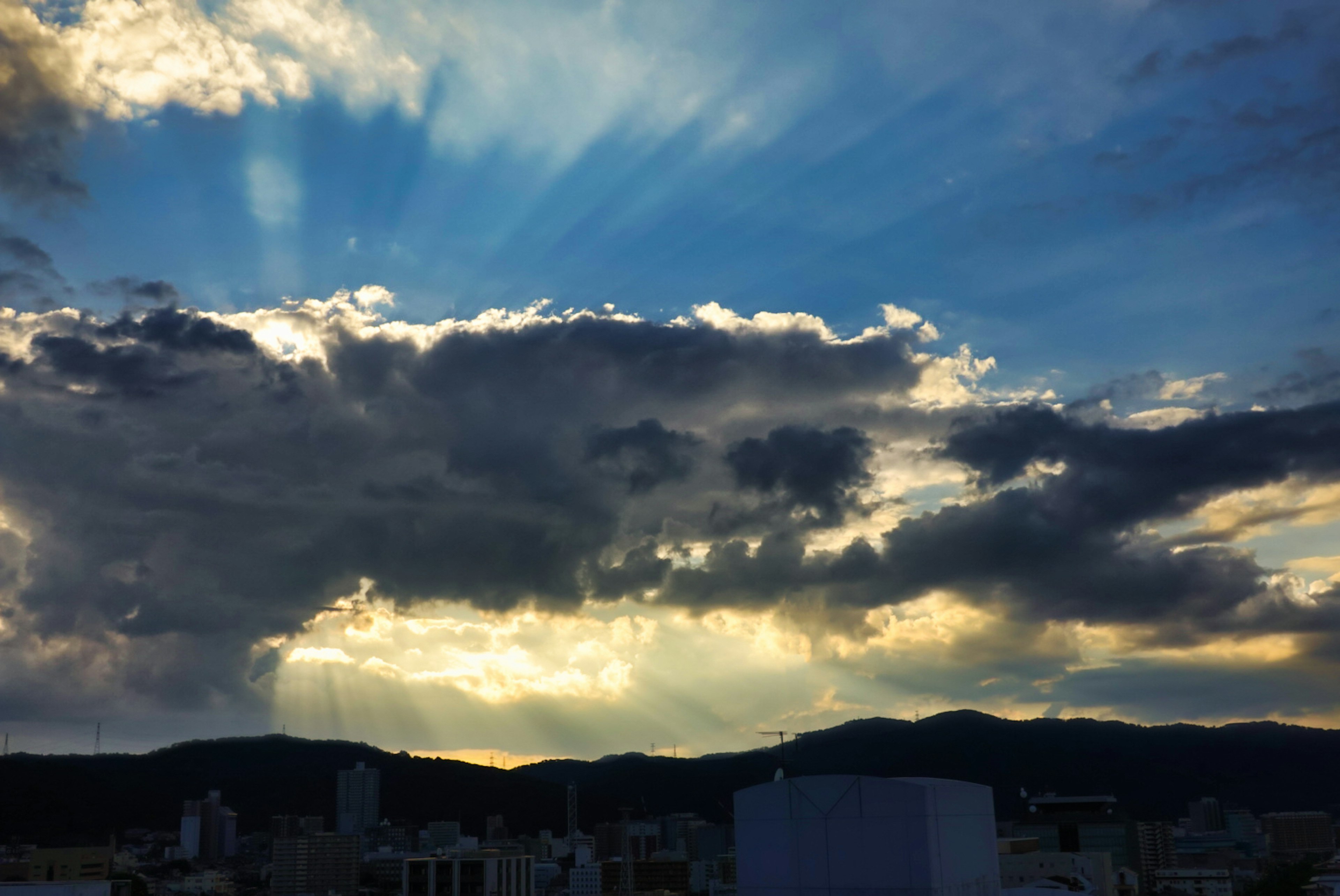 Una vista panoramica di nuvole e montagne con la luce del sole che filtra nel cielo