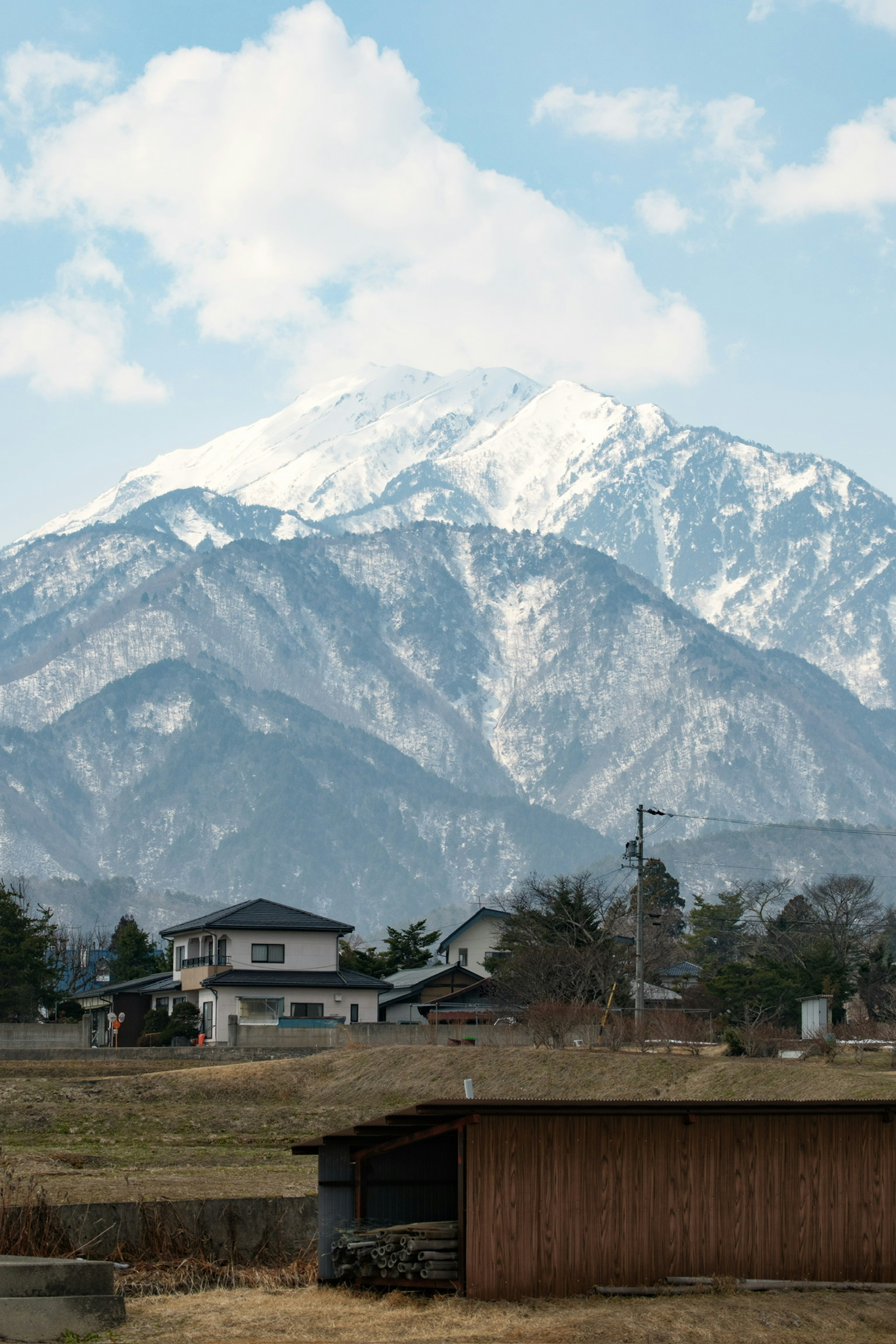 Gunung bersalju dengan pemandangan pedesaan