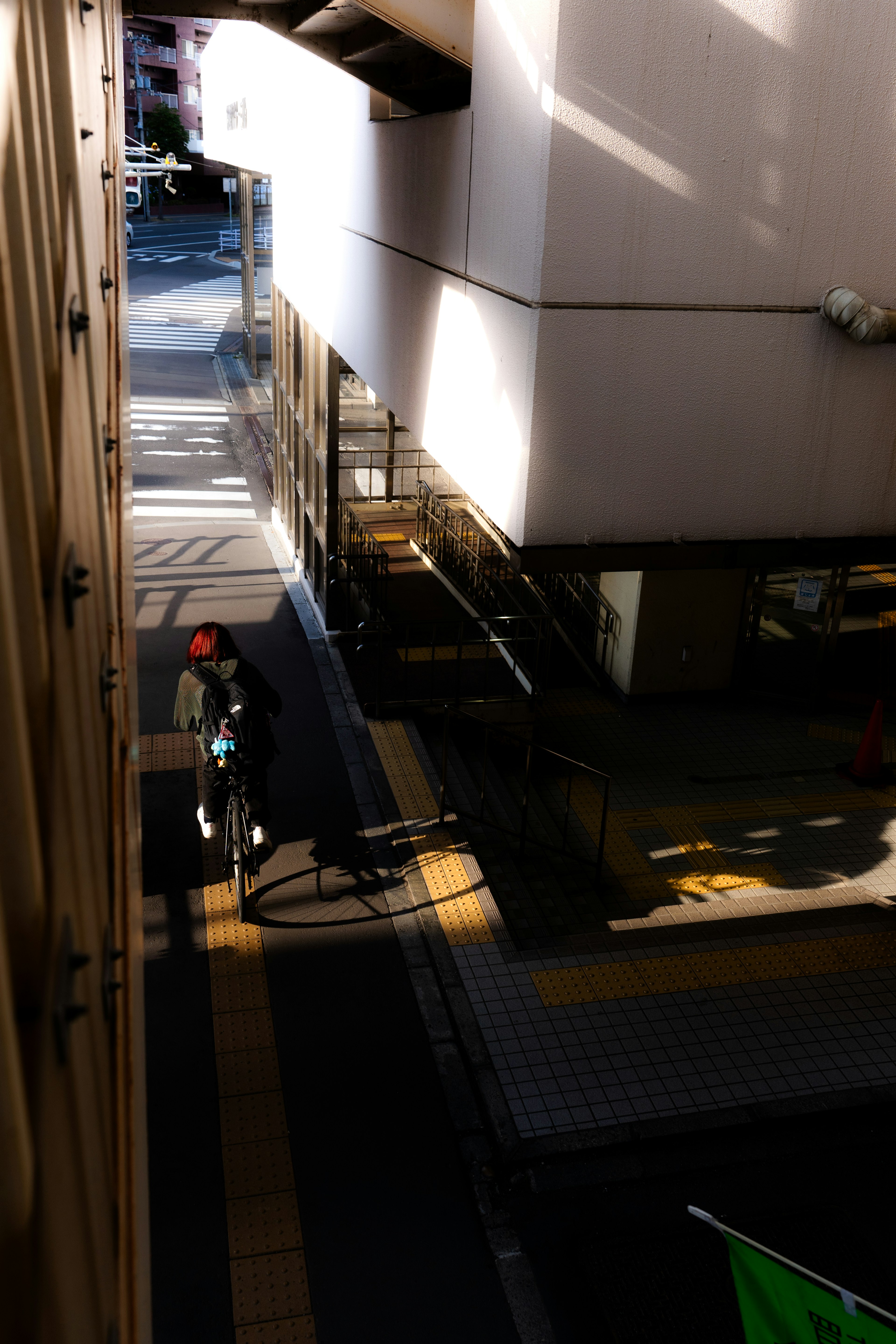 Arbeiter steht in einer engen Gasse mit Gebäudeschatten