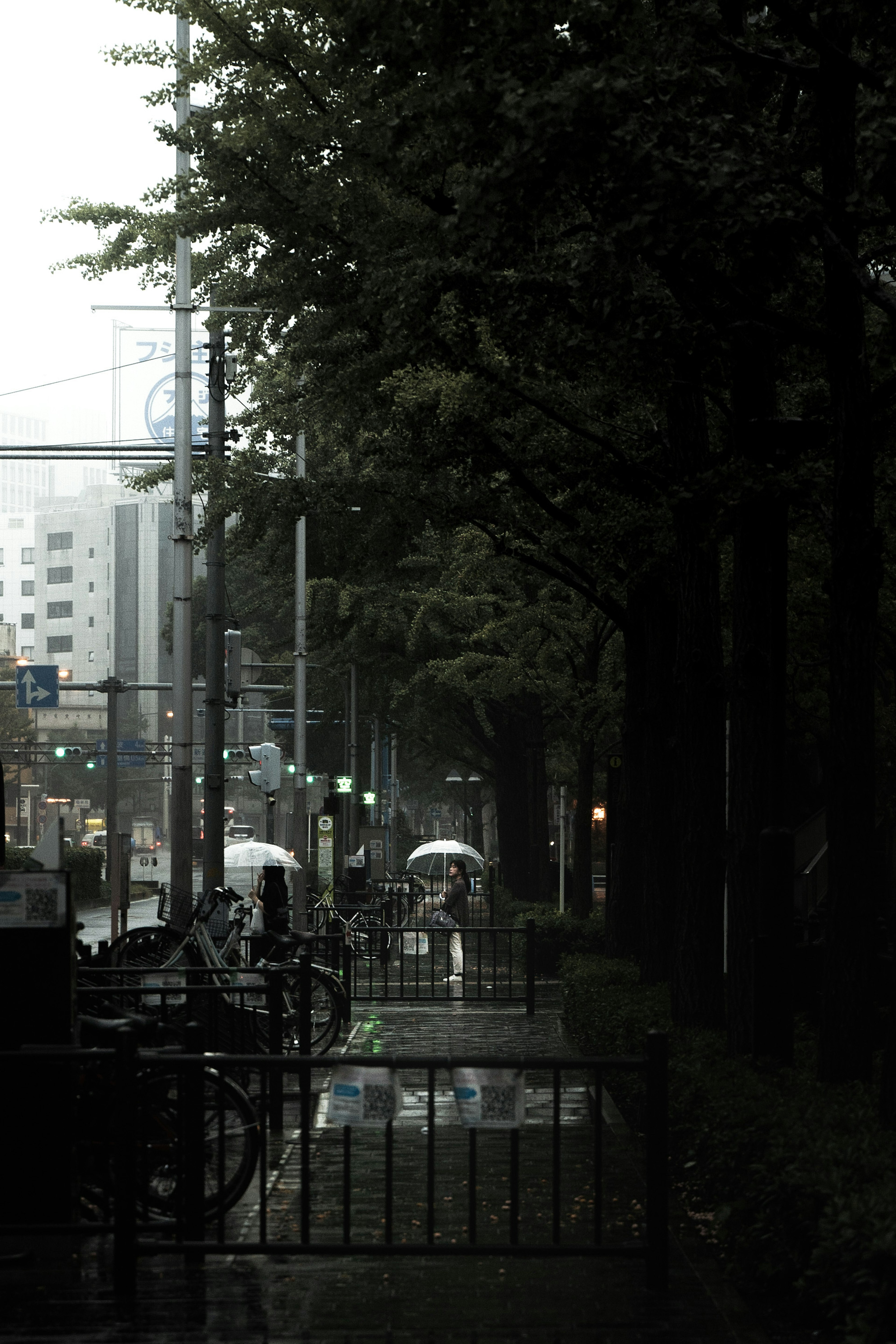 Eine regnerische Stadtansicht mit Menschen, die Regenschirme halten und nassen Straßen