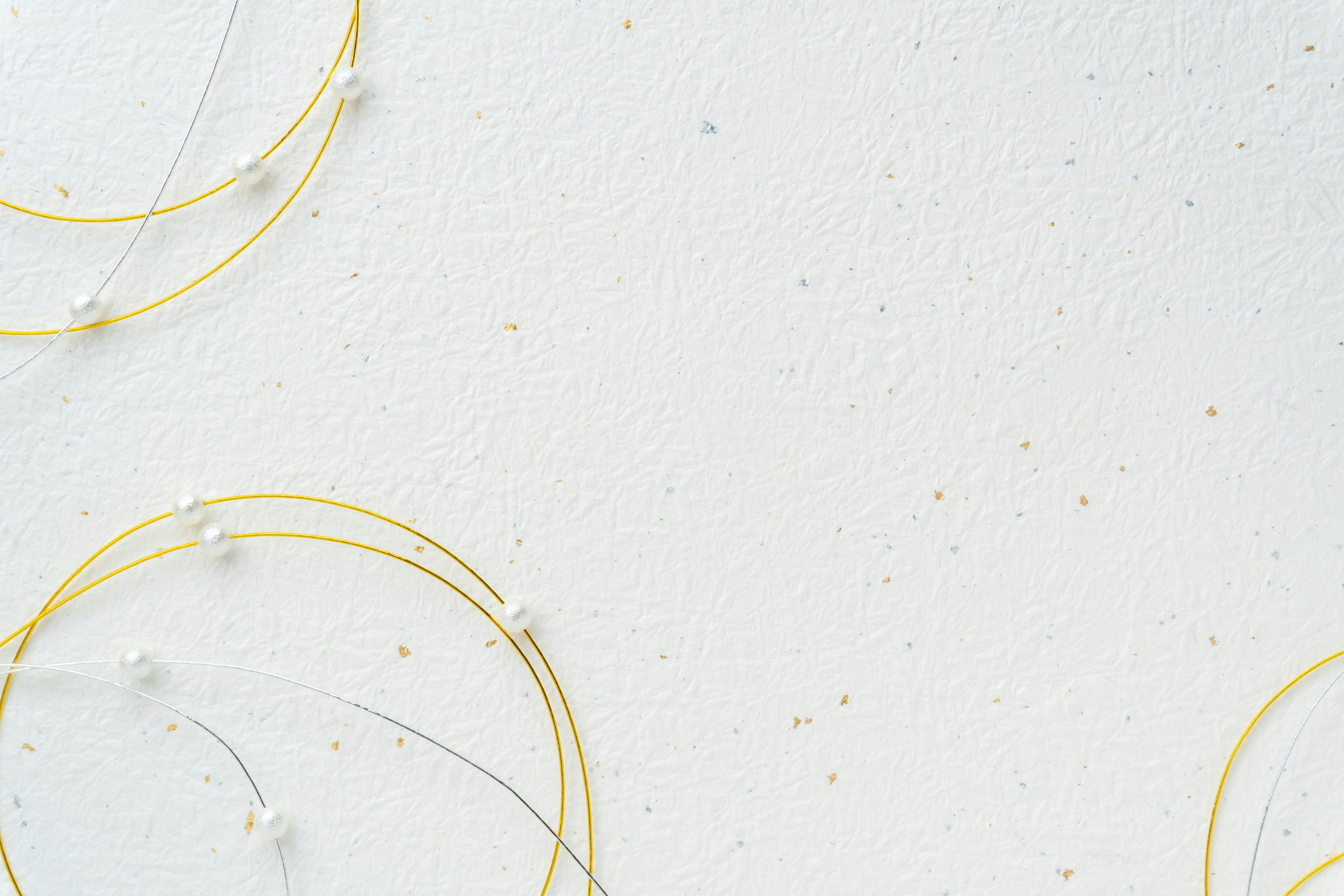 Design with golden circles and small pearls on a white background