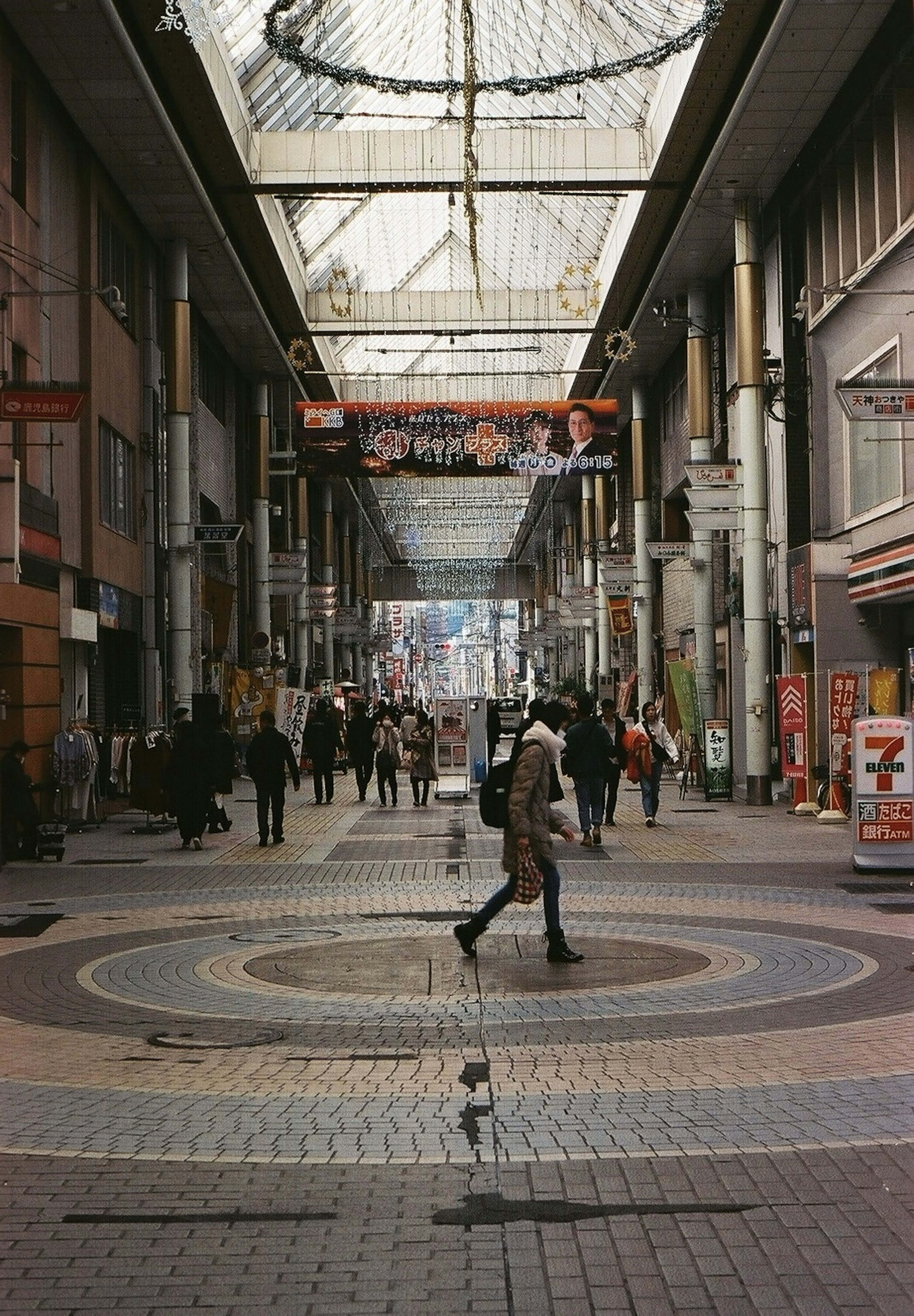 Personas caminando en un arcade comercial cubierto con un diseño circular