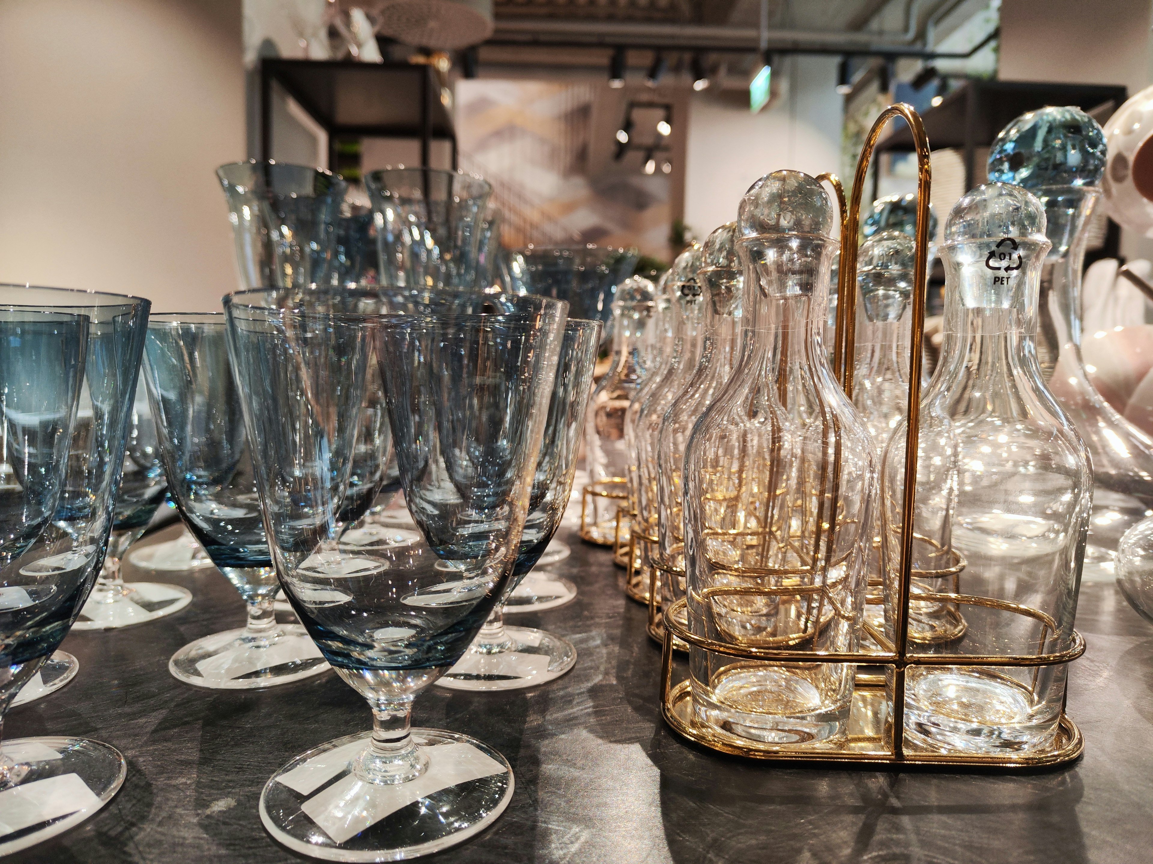 Exhibición de vasos azules y botellas transparentes sobre una mesa