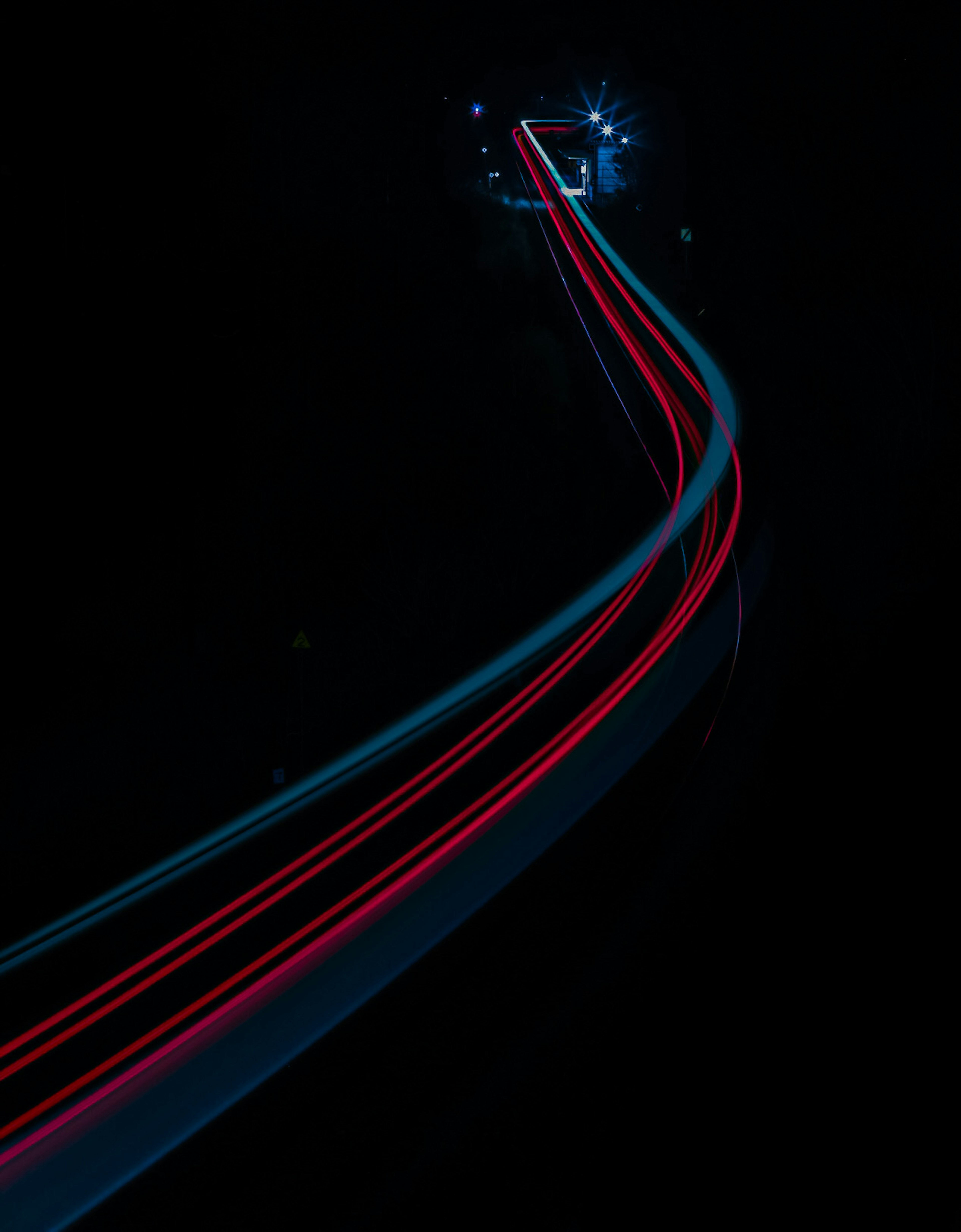 Long path with red and blue light trails against a dark background