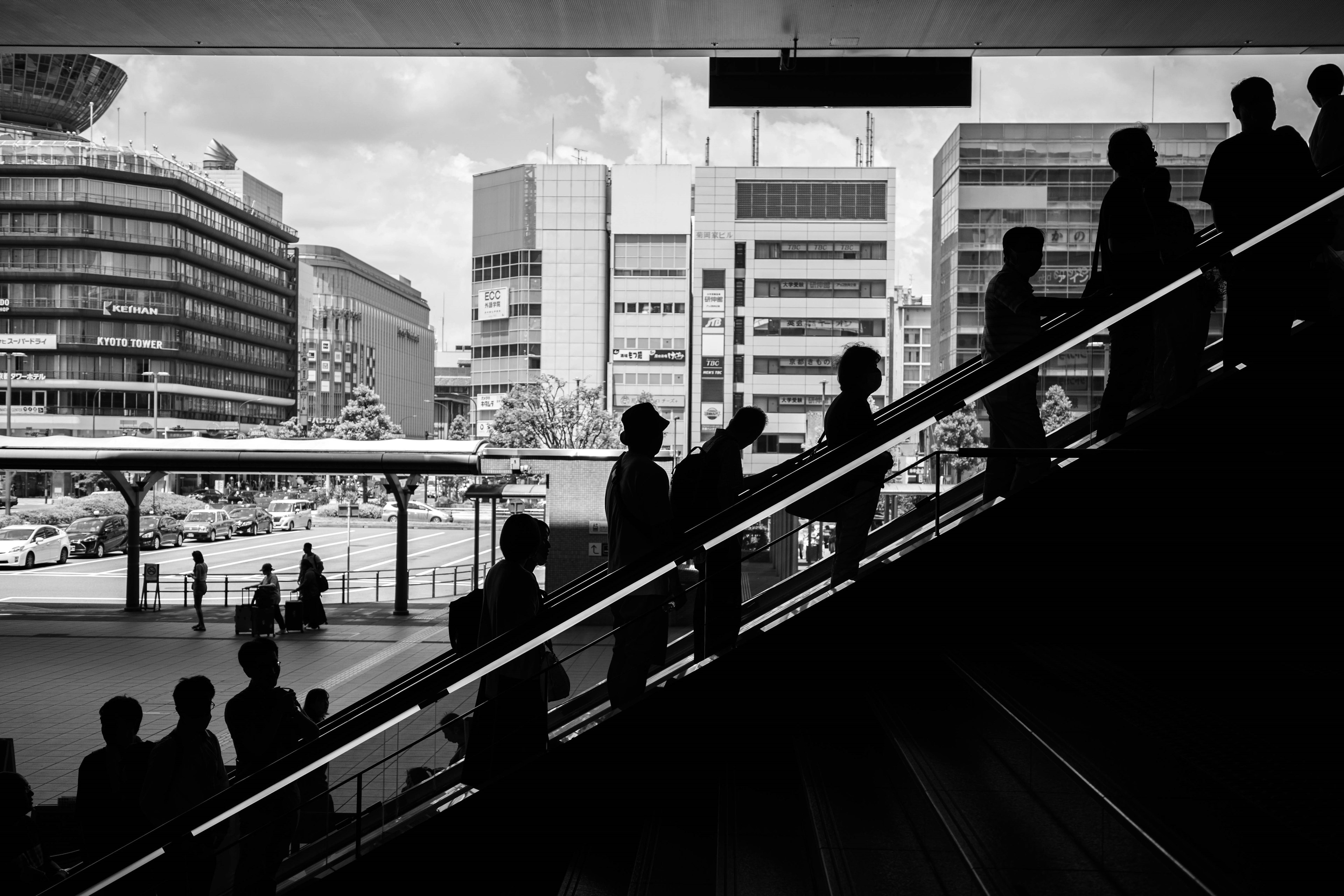 Silhouettes of people ascending stairs with a cityscape in the background