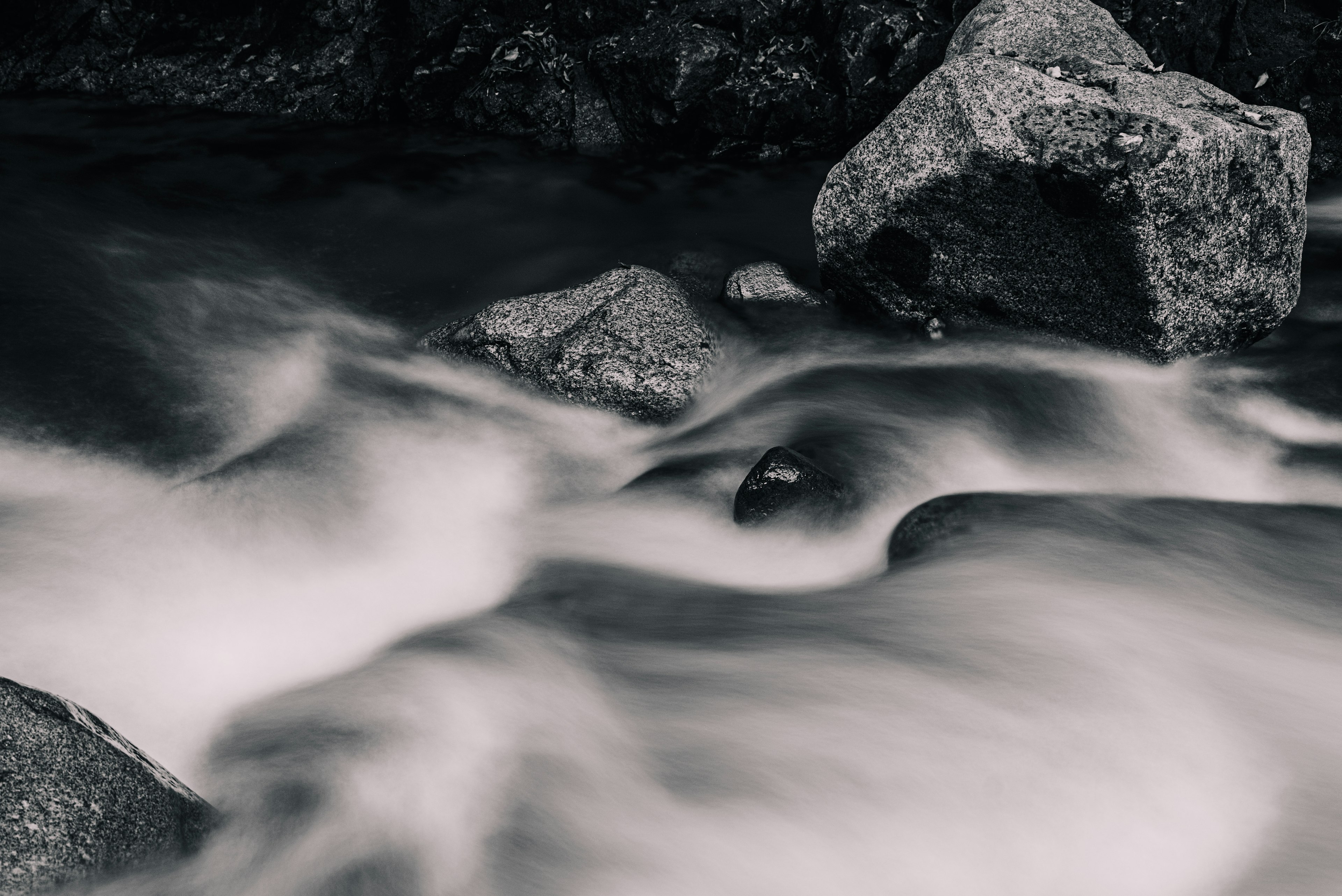 Black and white image of flowing water and rocks