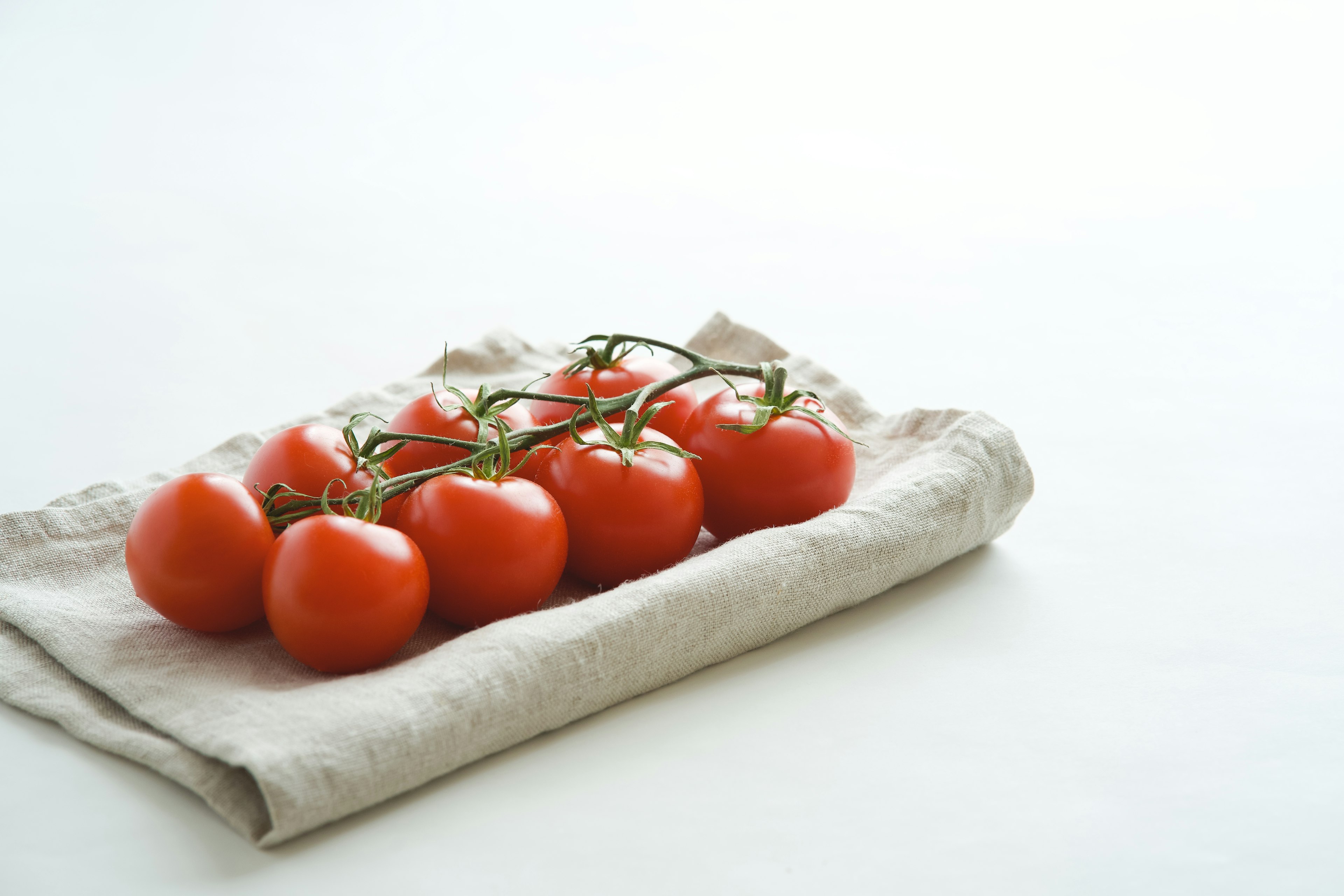 Fresh tomatoes arranged on a linen cloth