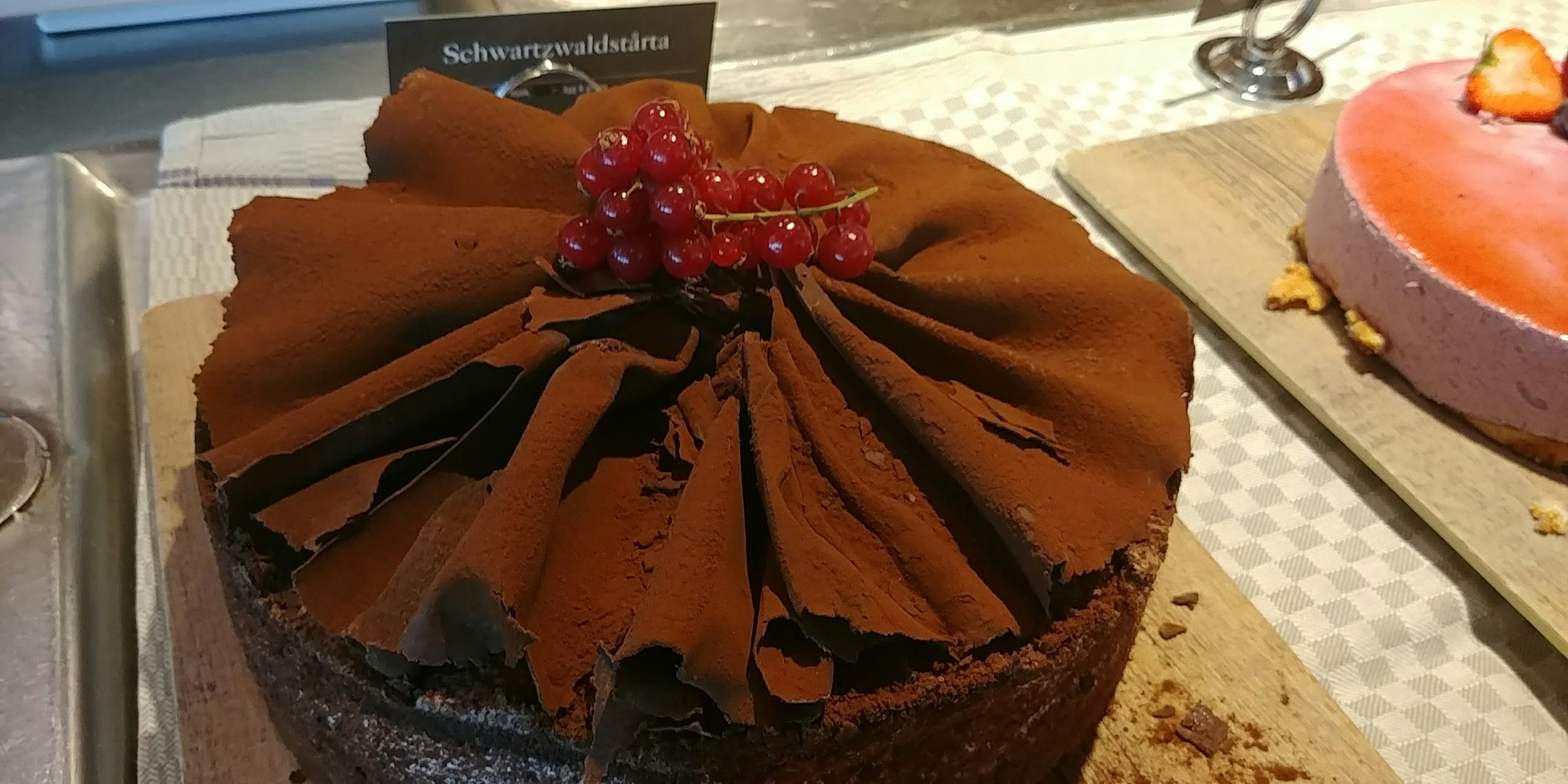 Gâteau au chocolat surmonté de baies rouges et de glaçage en chocolat texturé