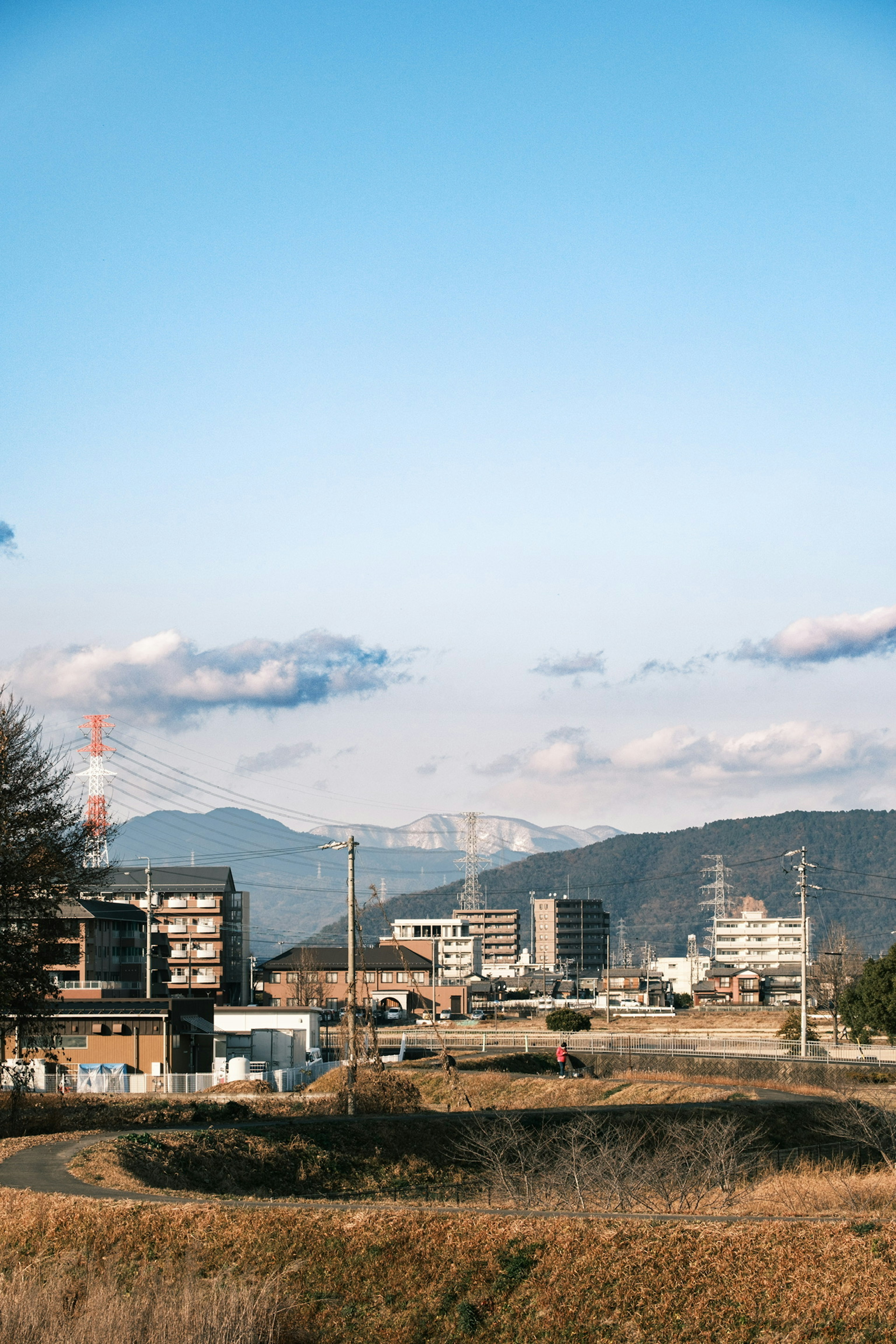 Urban landscape with buildings and mountains under a blue sky