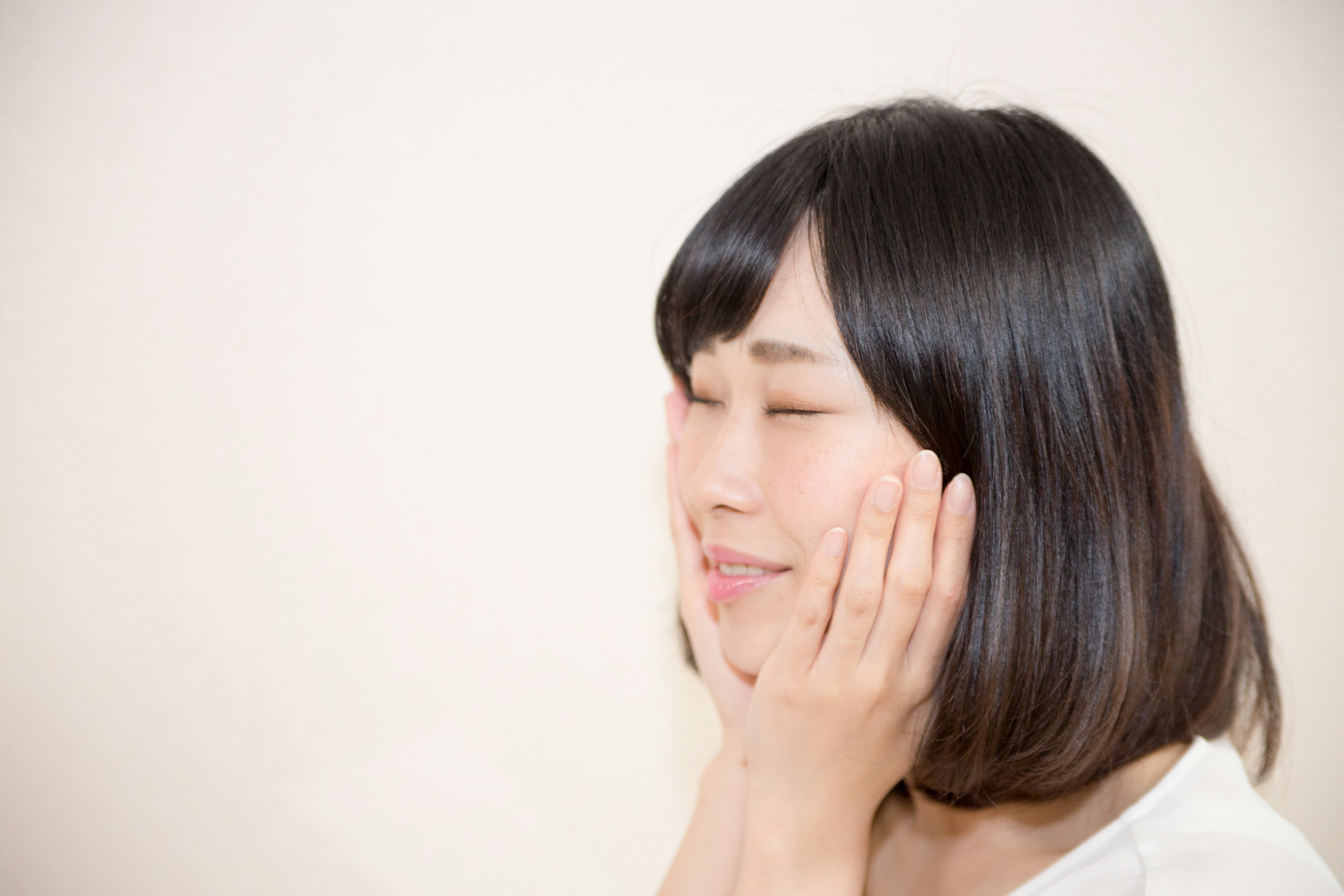 Woman smiling with her hands on her face