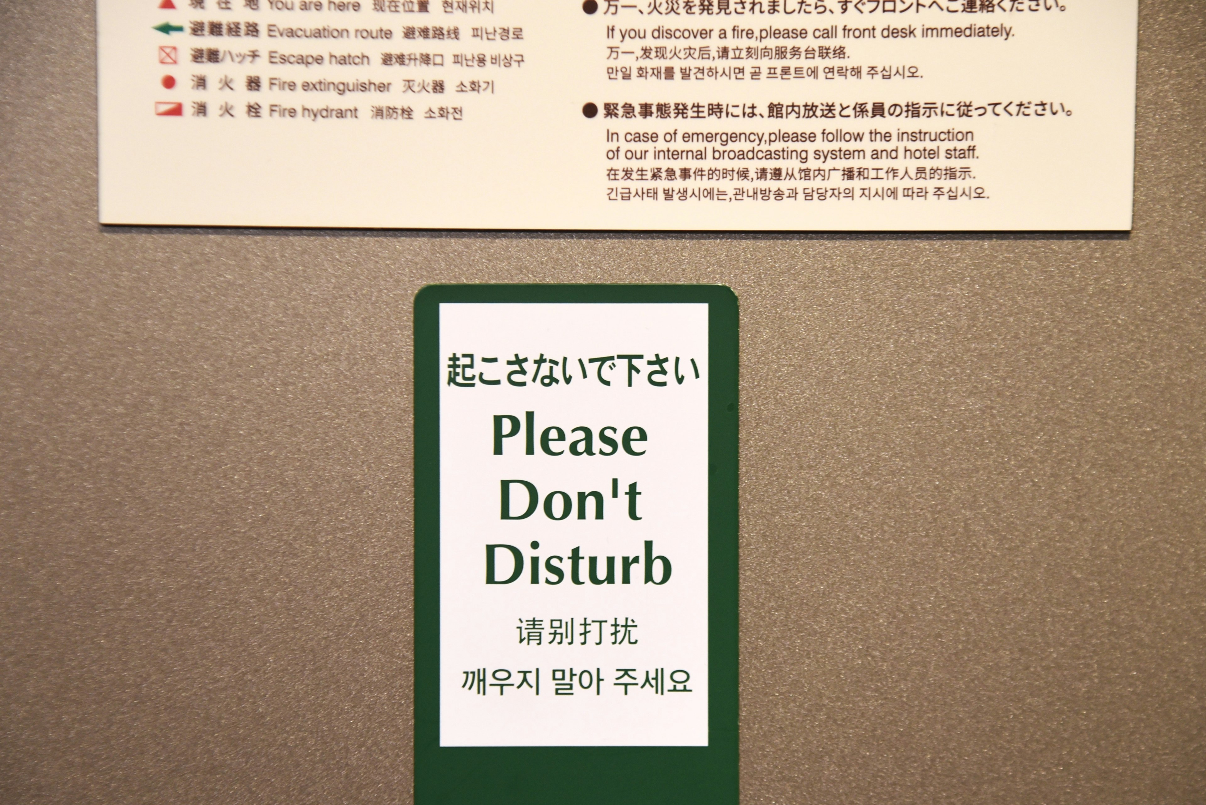 A door sign displaying Please Don't Disturb in multiple languages