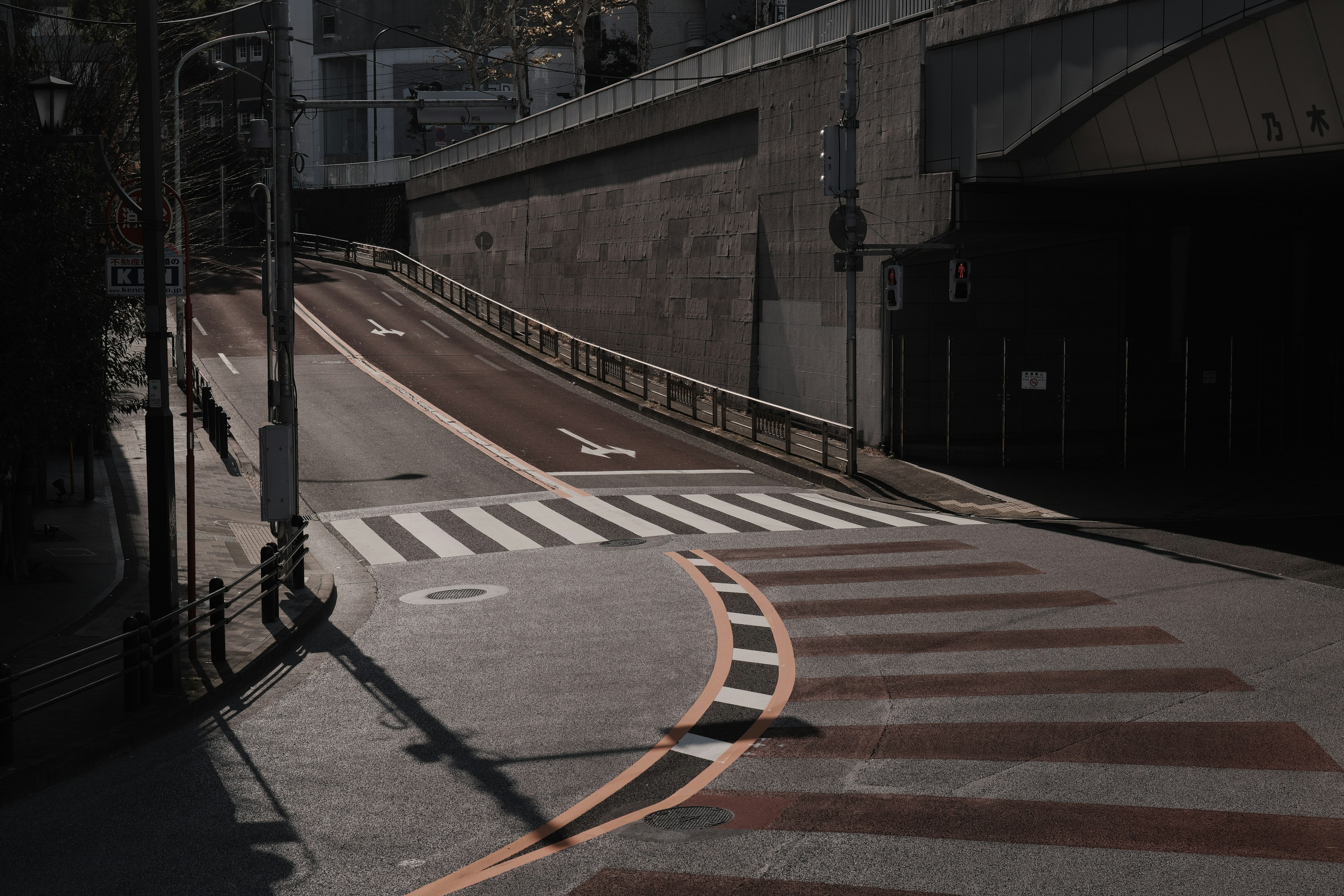 Intersección urbana con paso peatonal y carretera en sombra