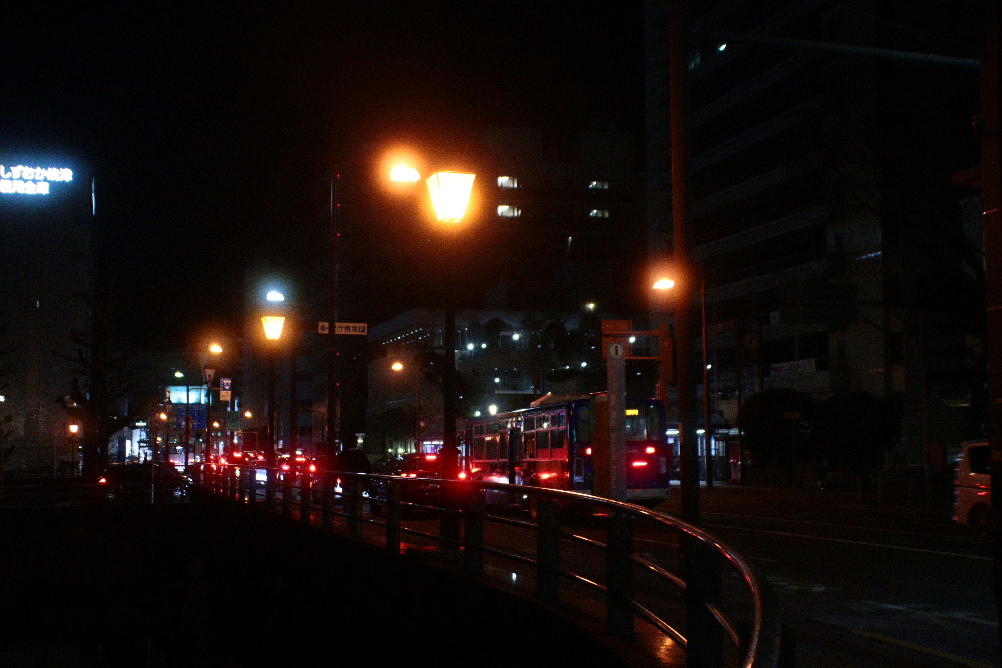 Carretera curva a lo largo de un paisaje urbano de noche con farolas brillantes