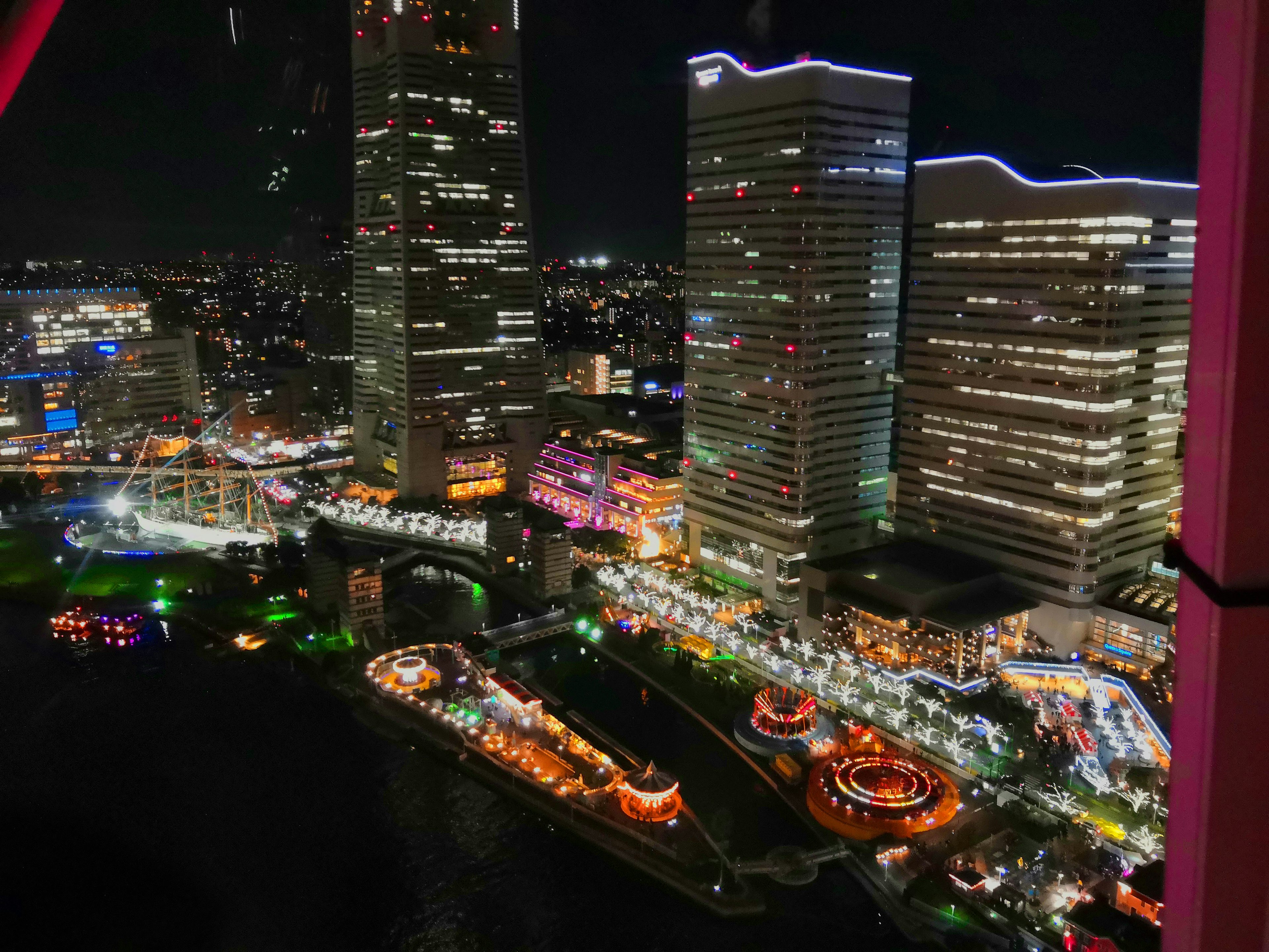 Vue nocturne de gratte-ciels avec lumières colorées et paysage urbain