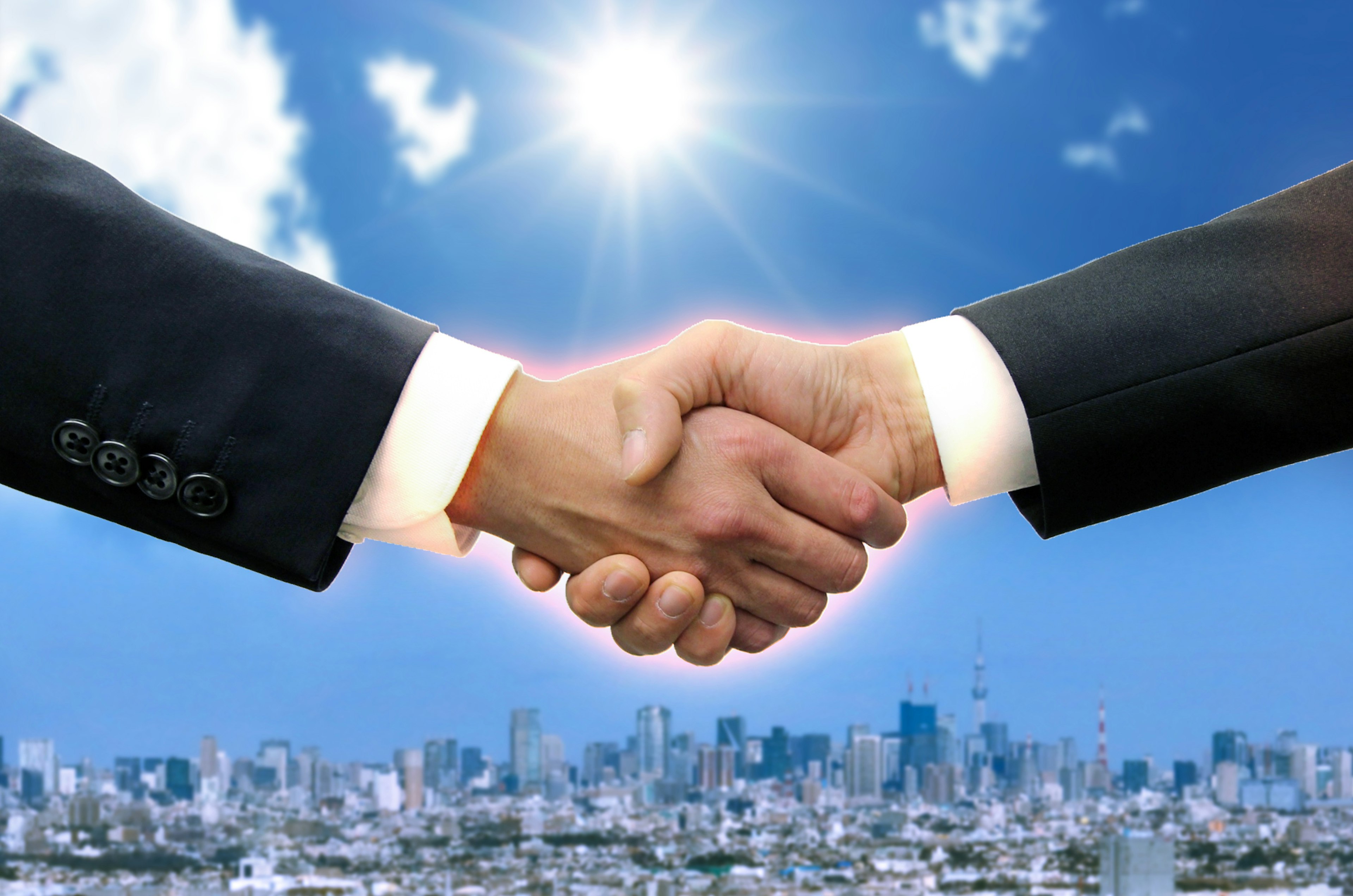 Handshake between businessmen with a city skyline in the background