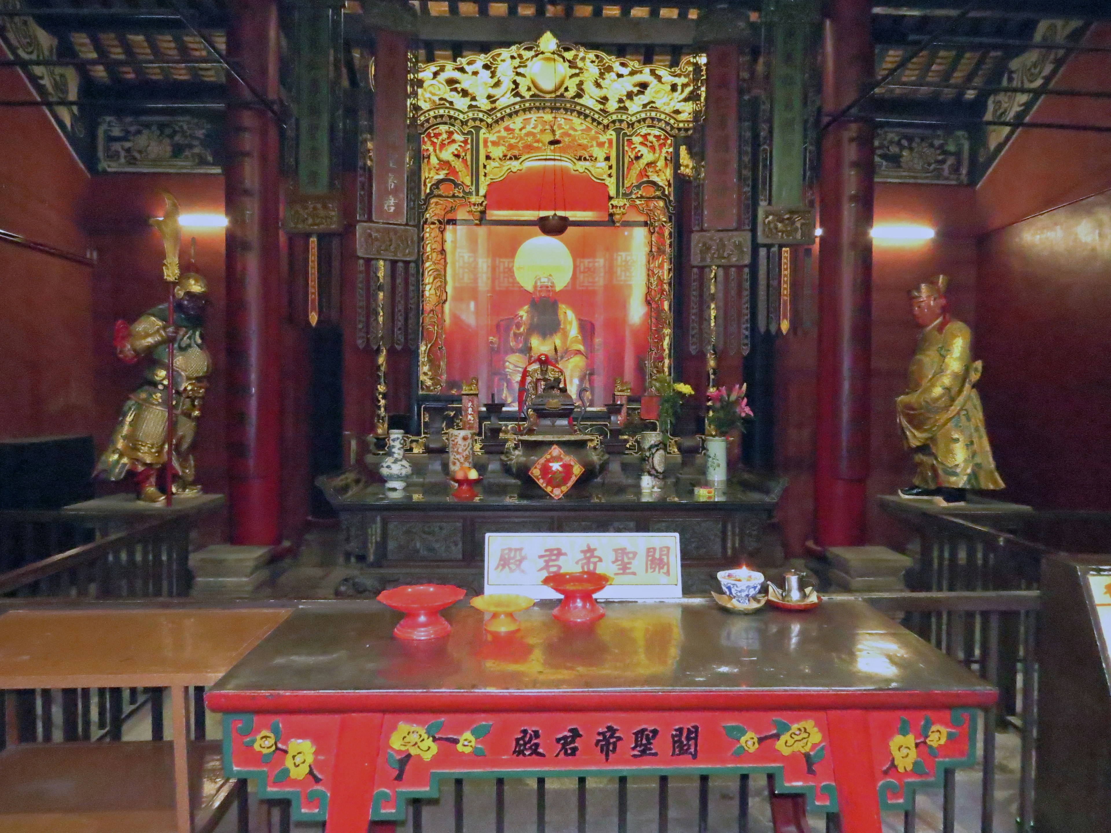 Interior de un templo con un altar y estatuas de Buda