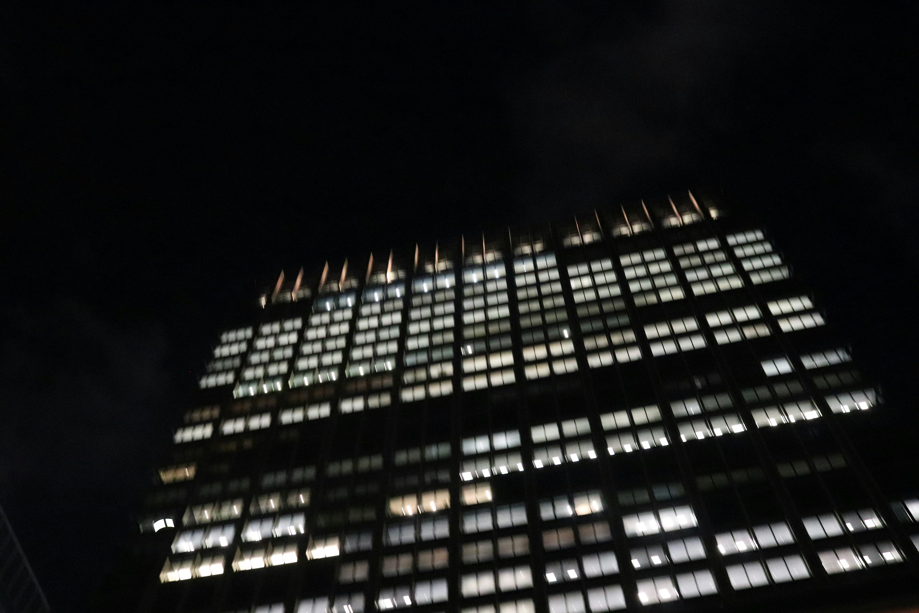 Photo of a building at night with bright windows