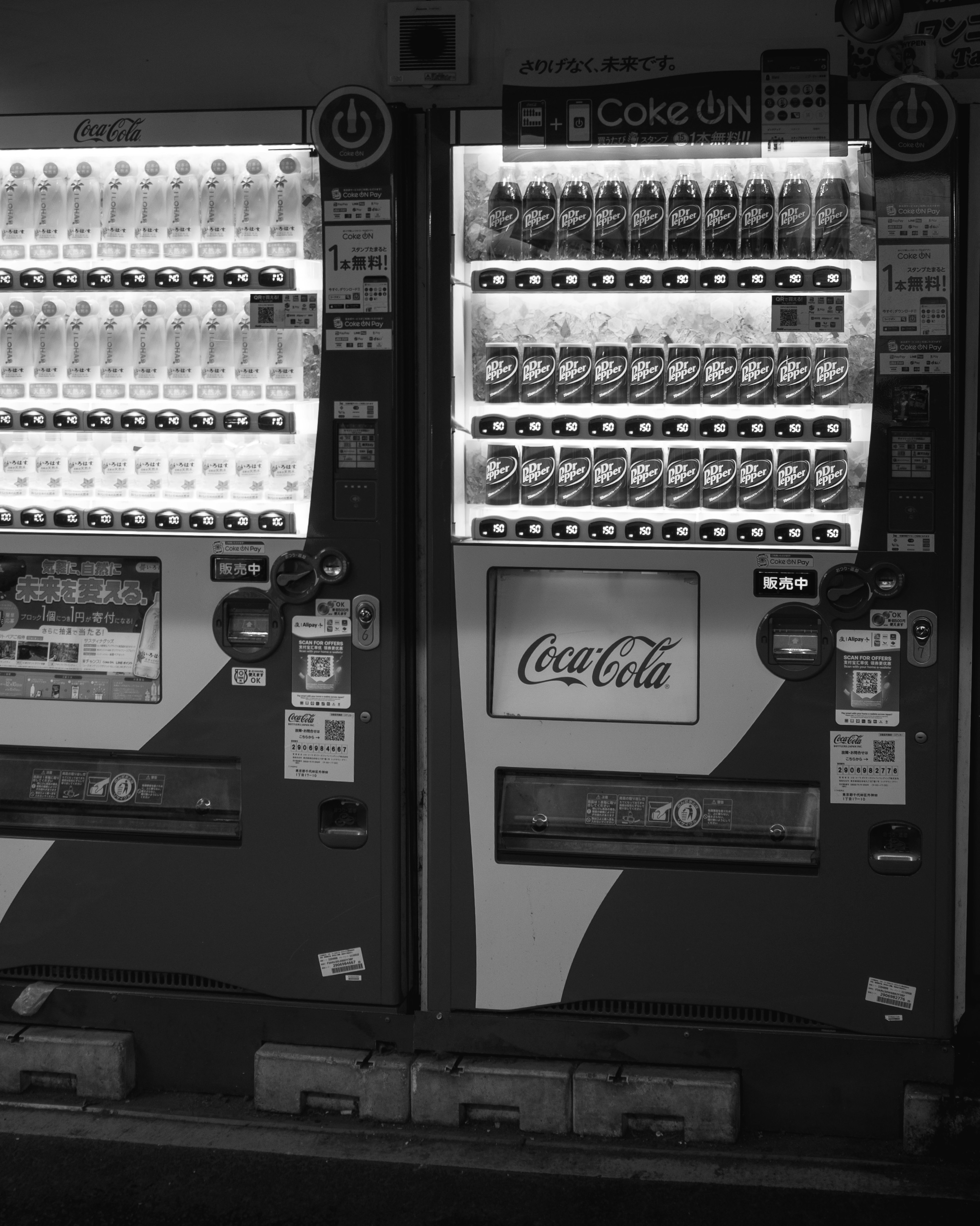 Primer plano de máquinas expendedoras en blanco y negro con logo de Coca-Cola