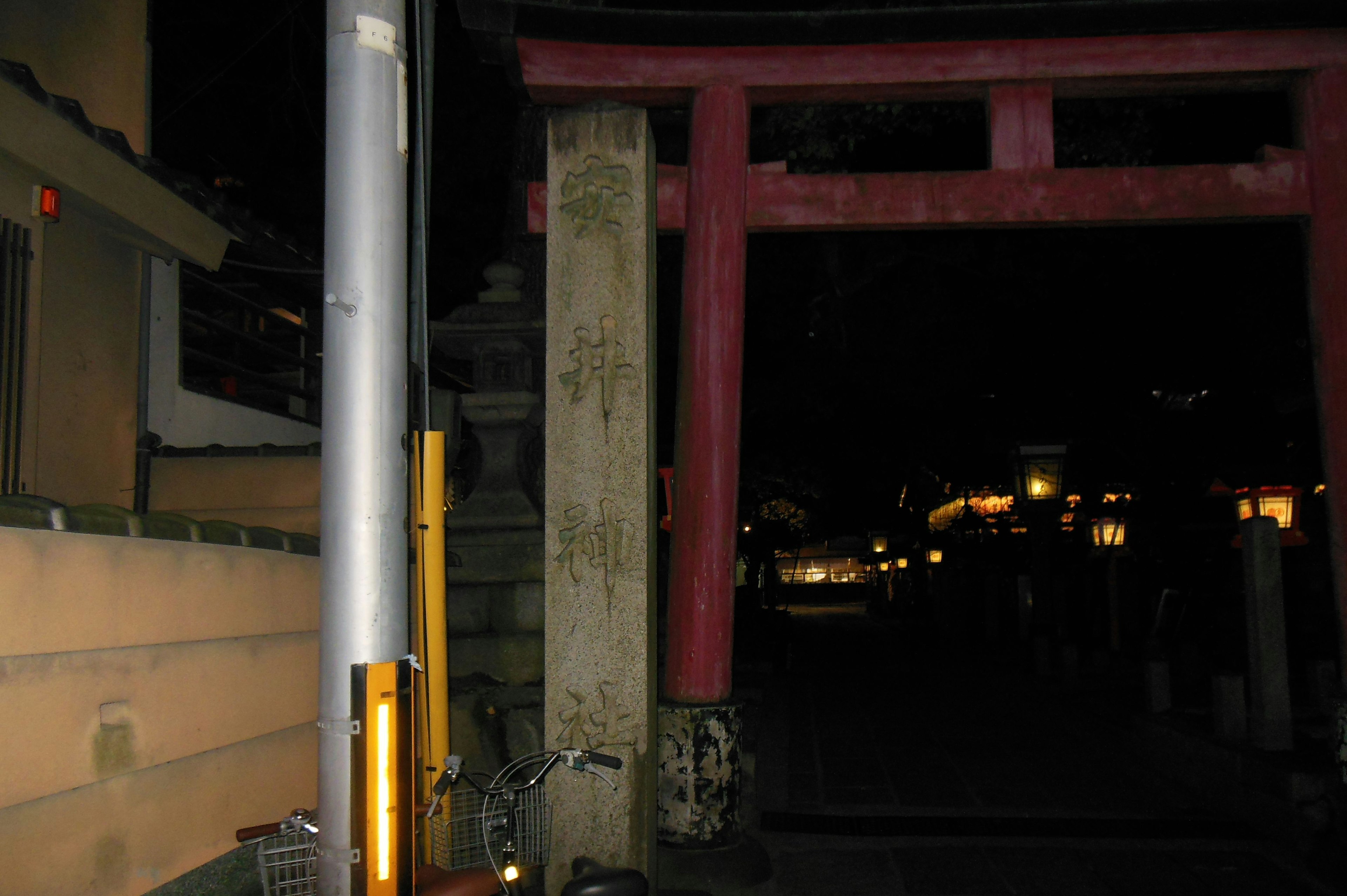 夜の鳥居の前に立つ街灯と道