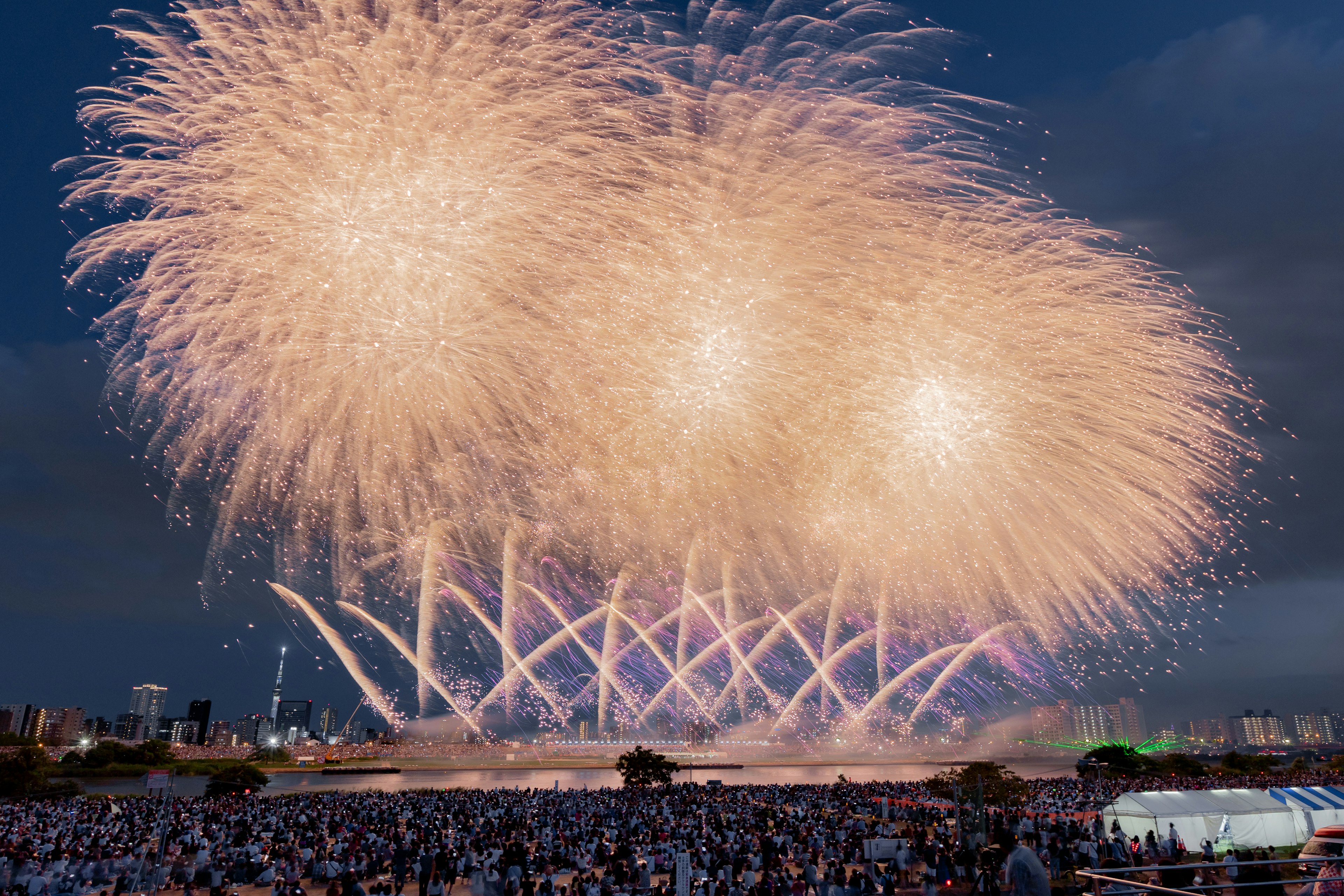 夜空に広がる大きな花火と観衆のシルエット