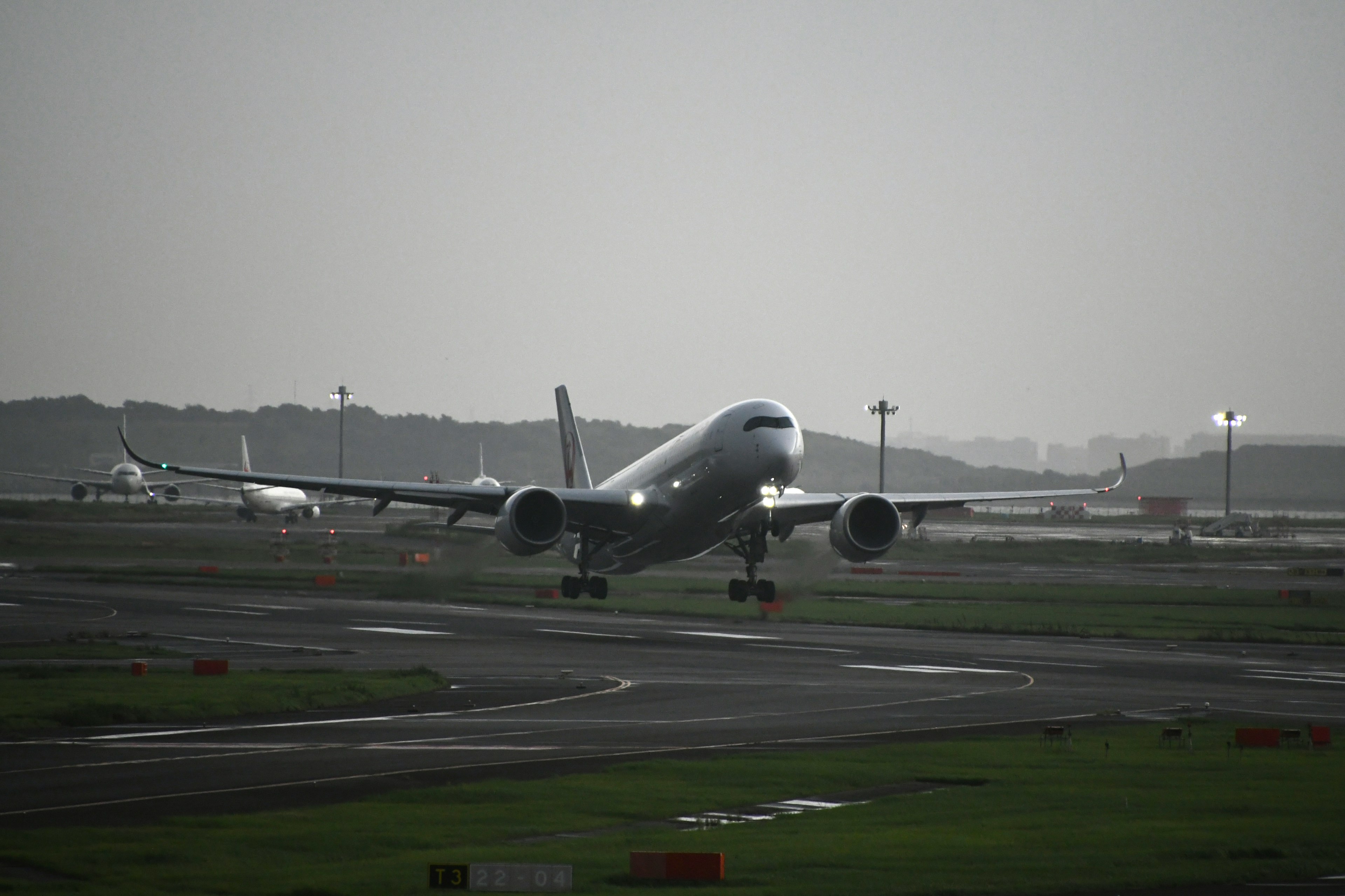 空港の滑走路で離陸する旅客機と薄暗い背景