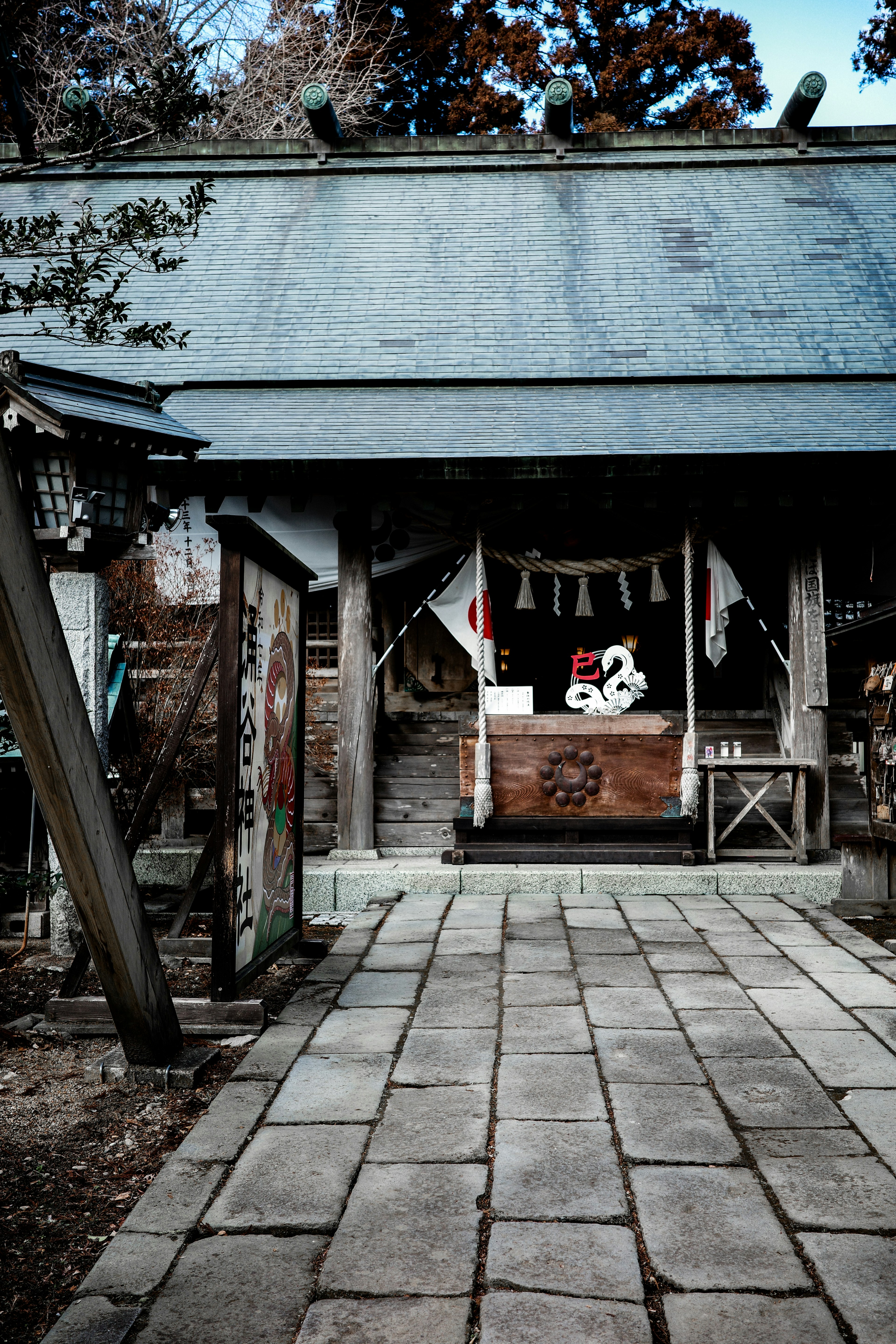 古い神社の入り口が見える石畳の道と伝統的な装飾