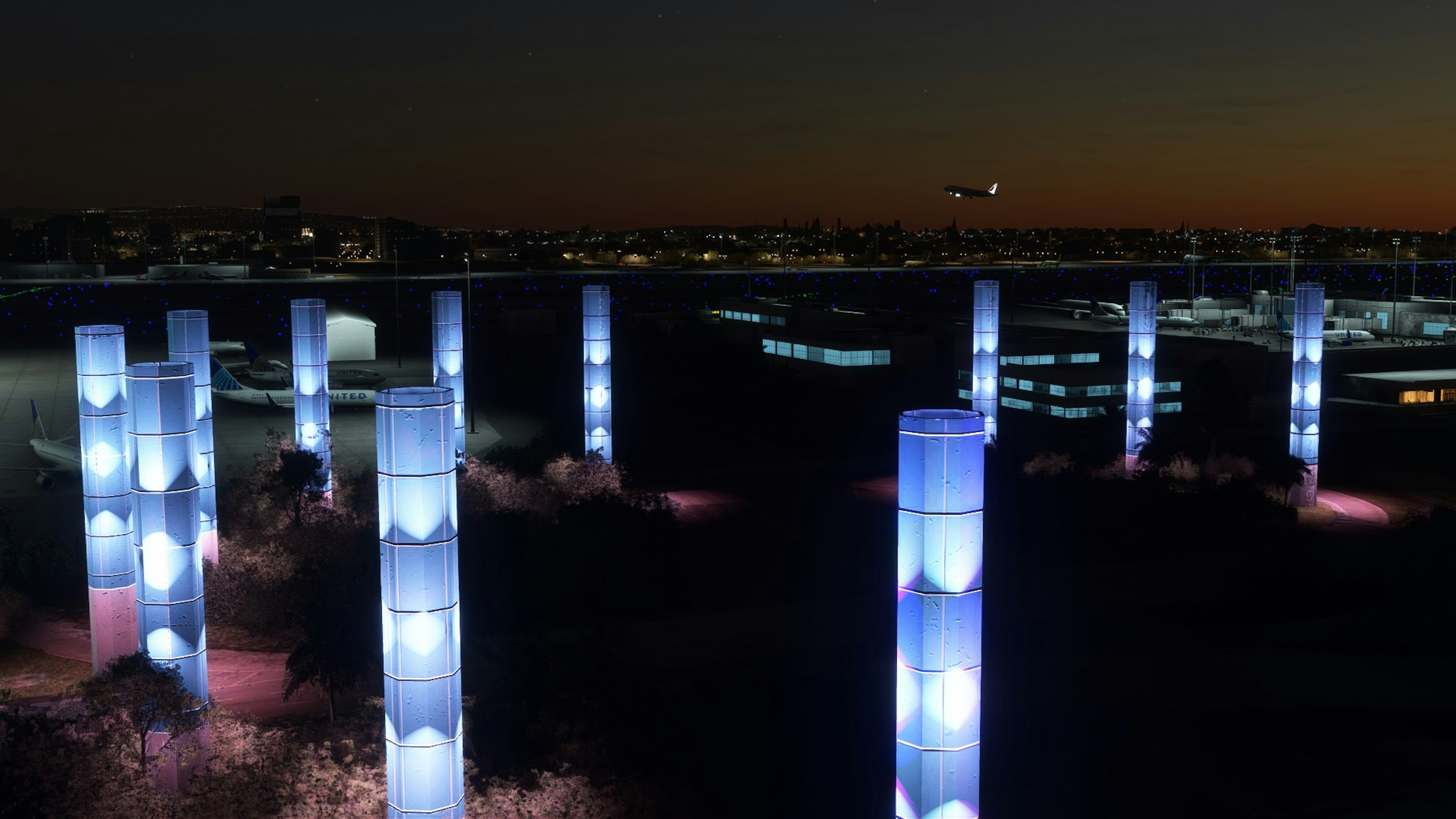 Illuminated cylindrical structures in a night cityscape with mist