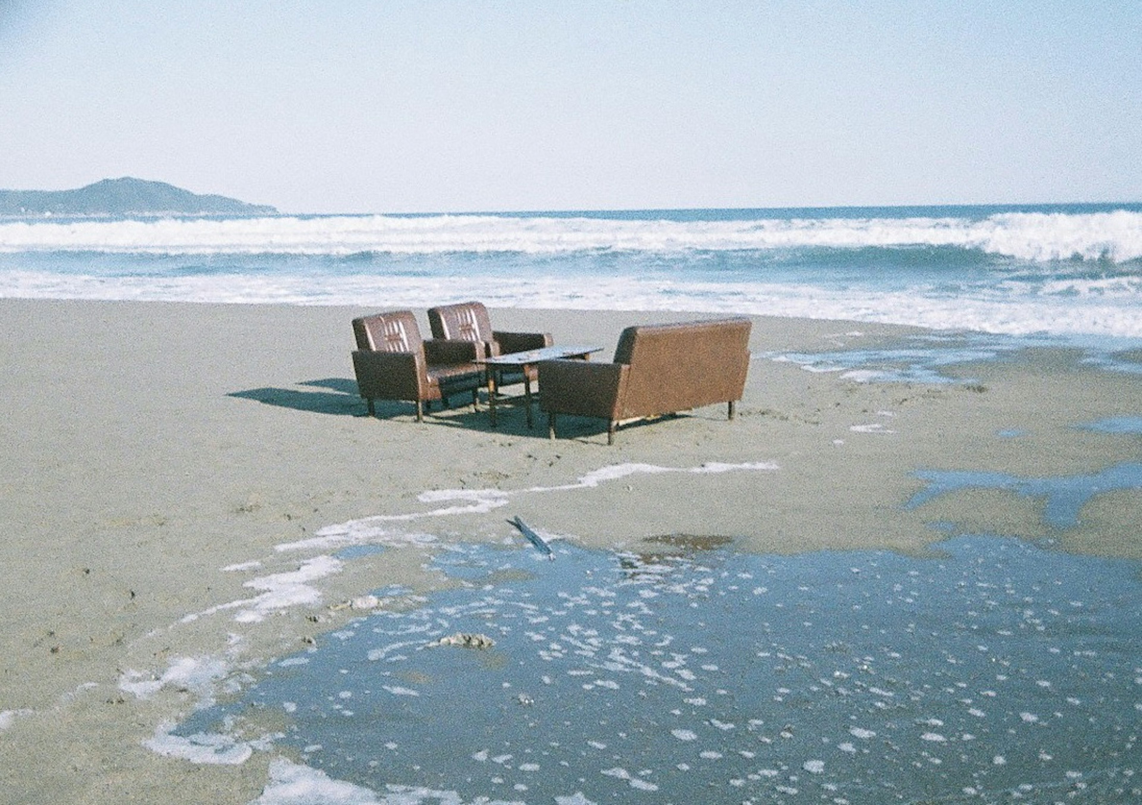 Sofaset auf dem Strand mit Wellen im Hintergrund