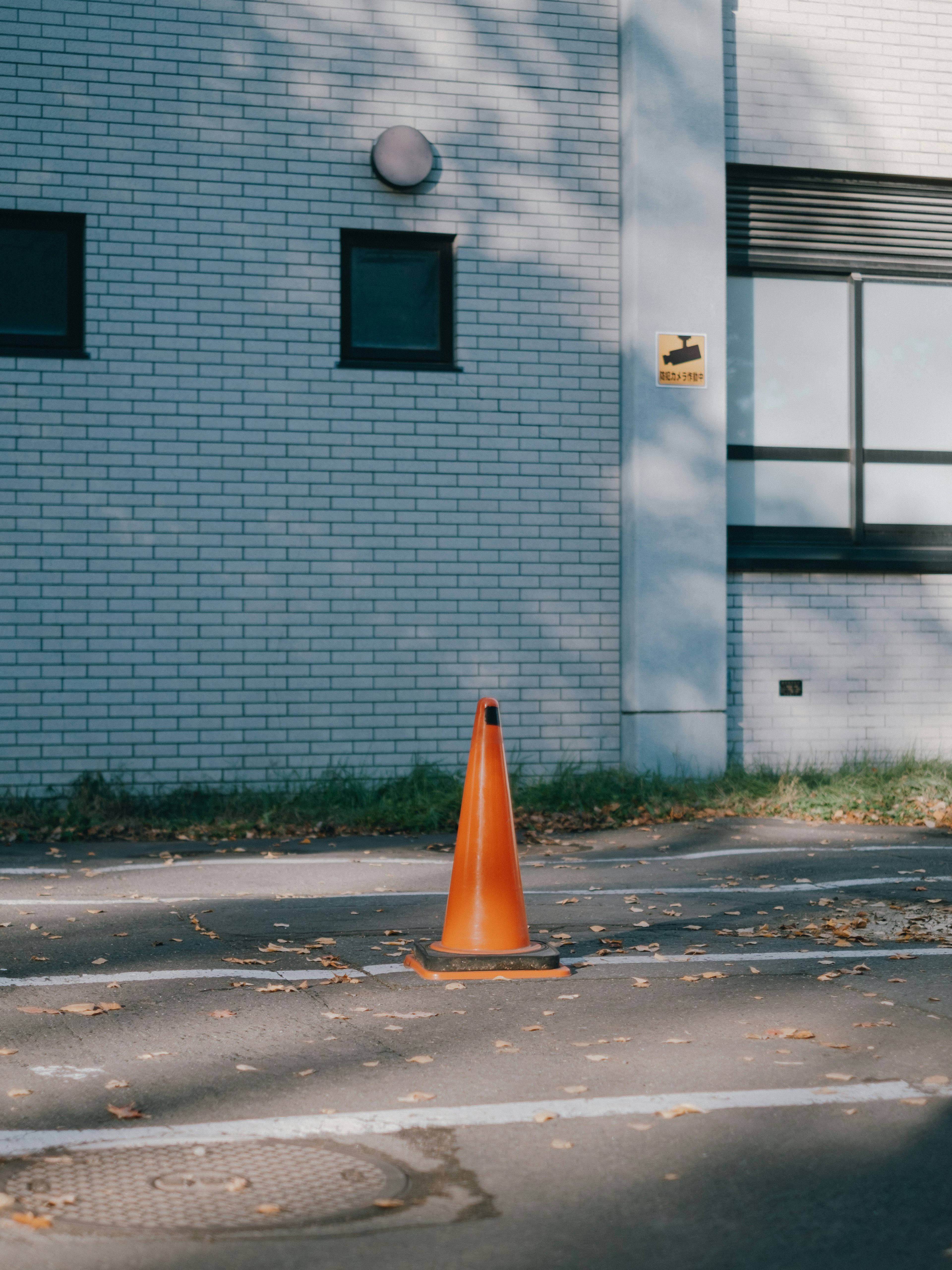 Sebuah cone lalu lintas oranye diletakkan di jalan depan sebuah bangunan