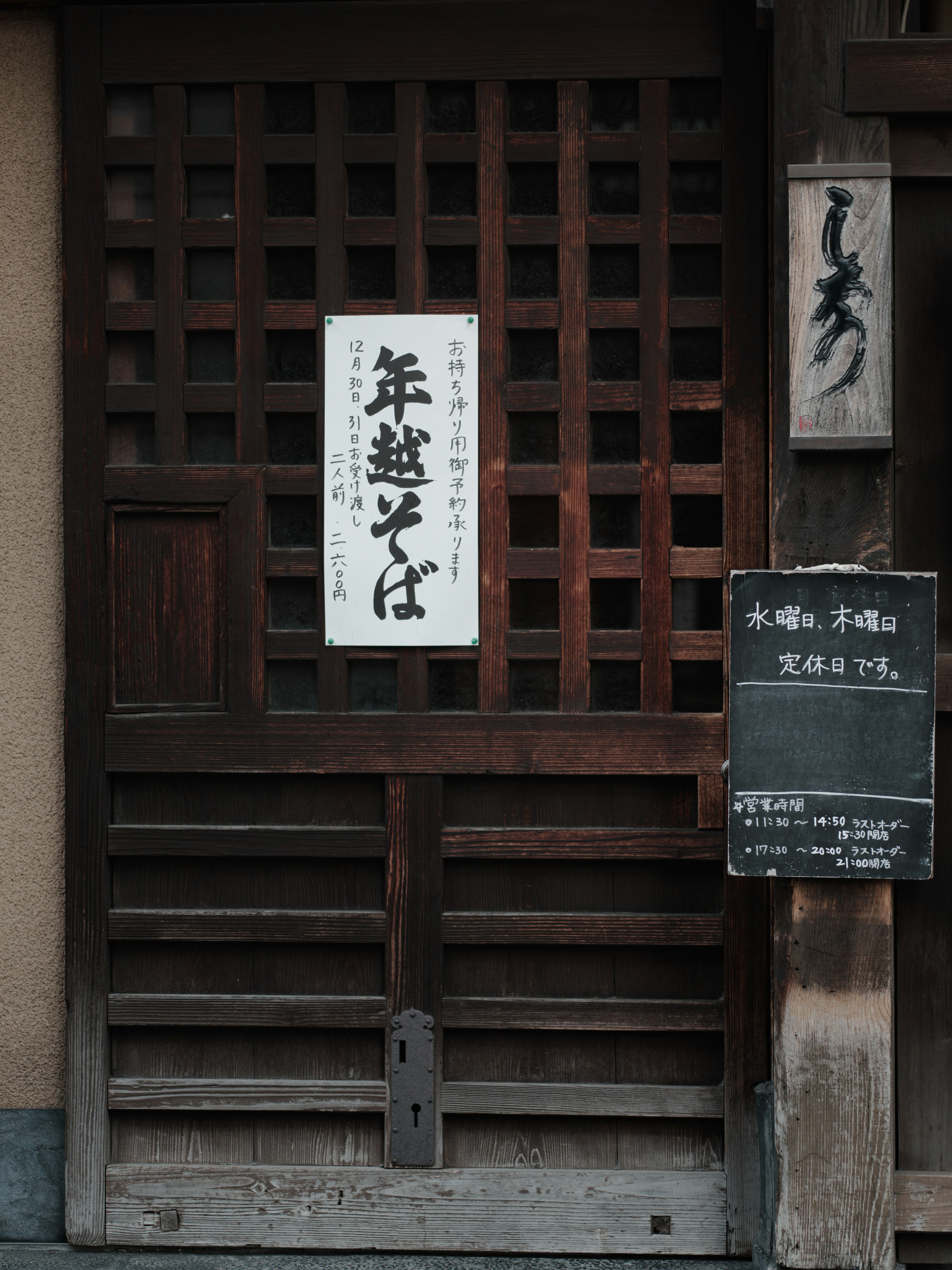 Traditionelle Holztür mit einem Schild und japanischen Zeichen