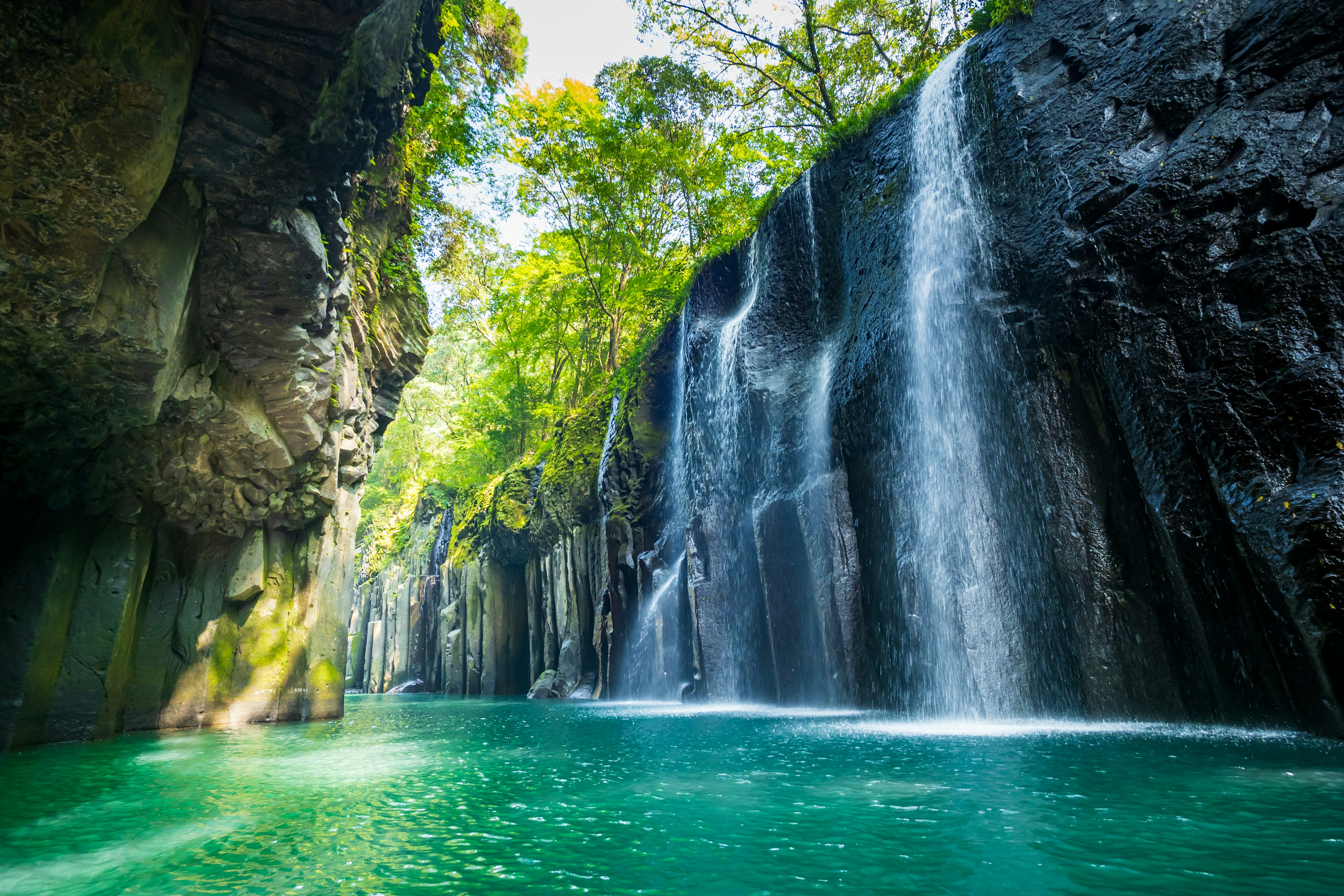 A stunning waterfall with turquoise water surrounded by lush greenery