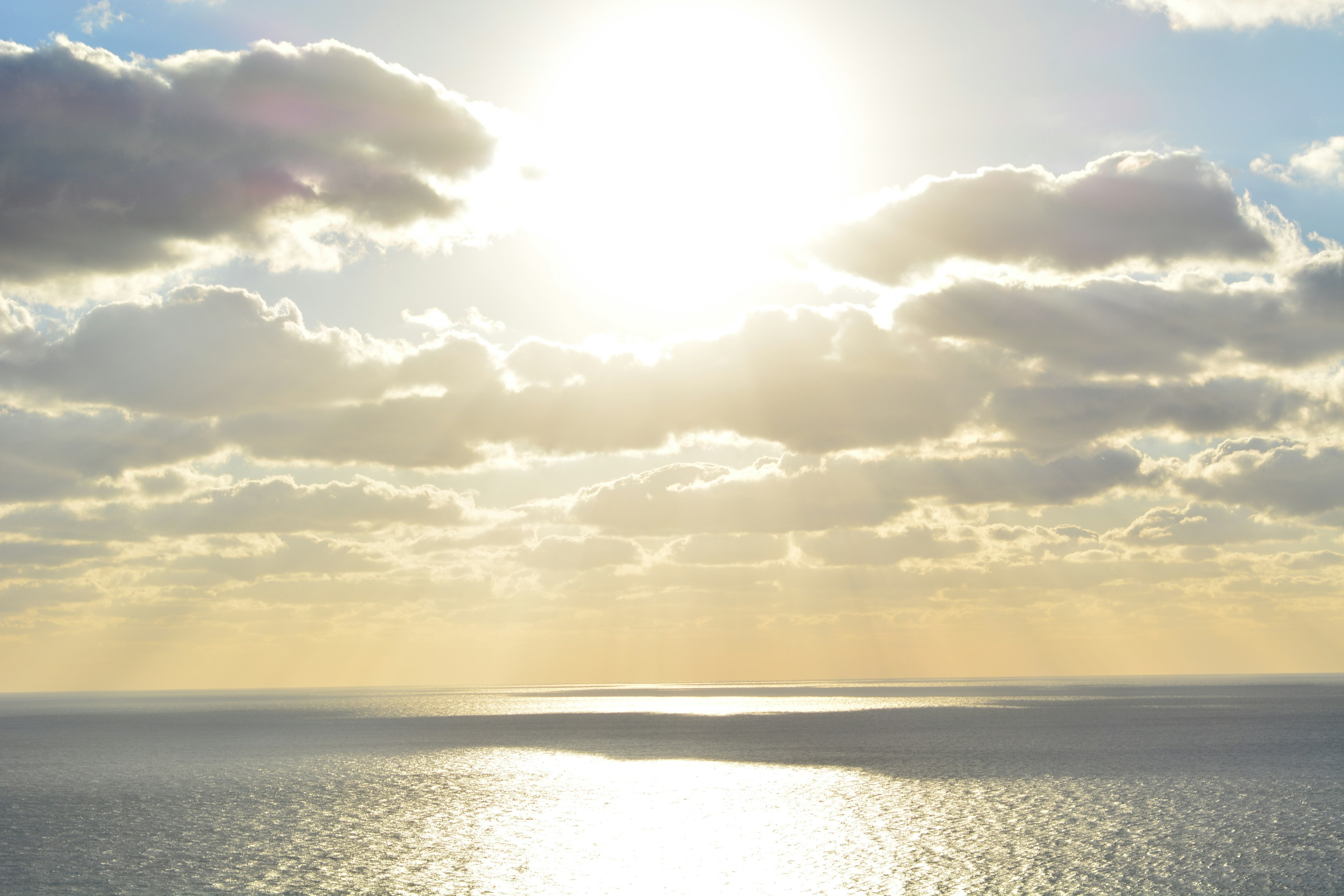 Schöne Landschaft mit der Sonne, die über das blaue Meer und die Wolken scheint