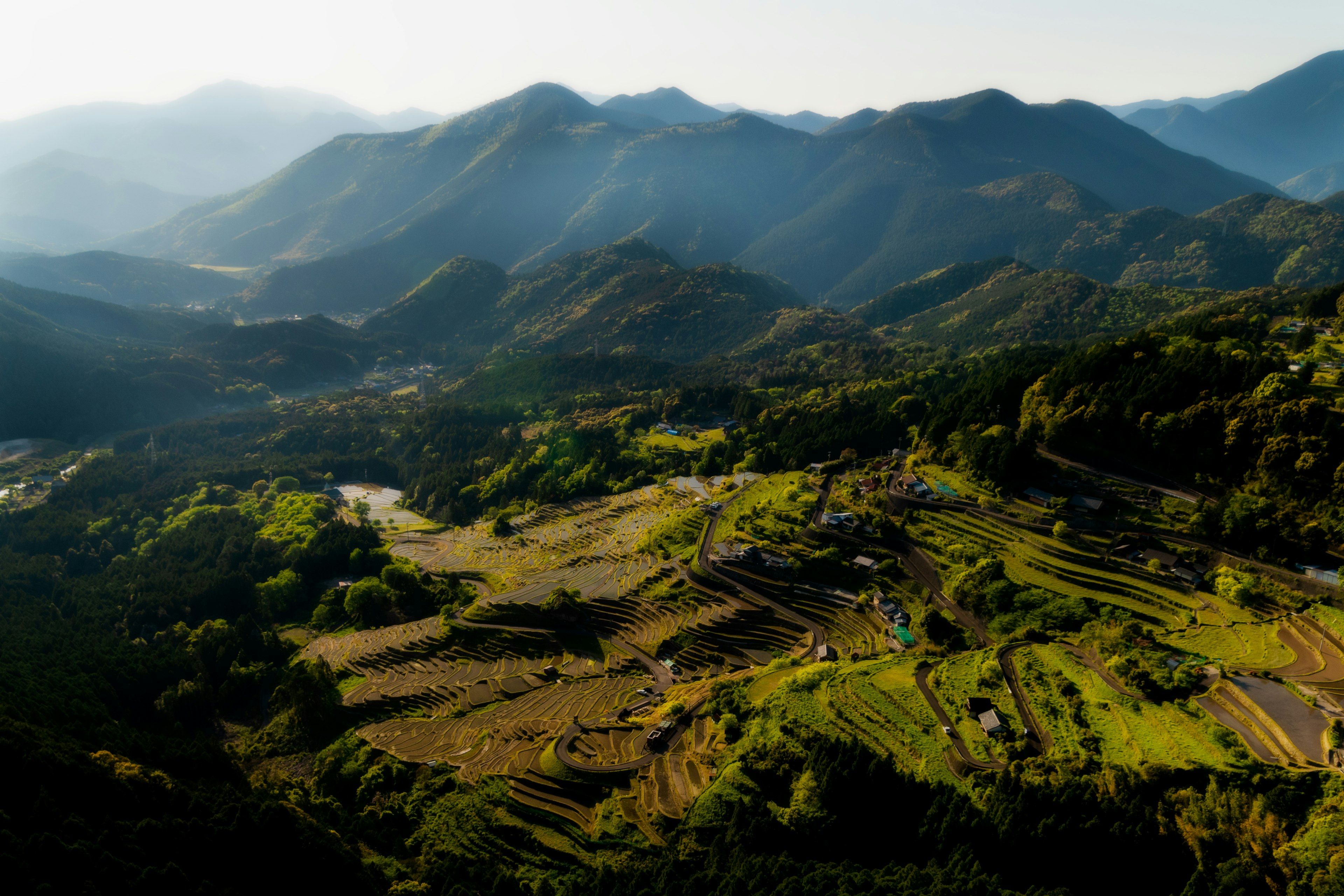 山々に囲まれた緑豊かな風景のパノラマ写真