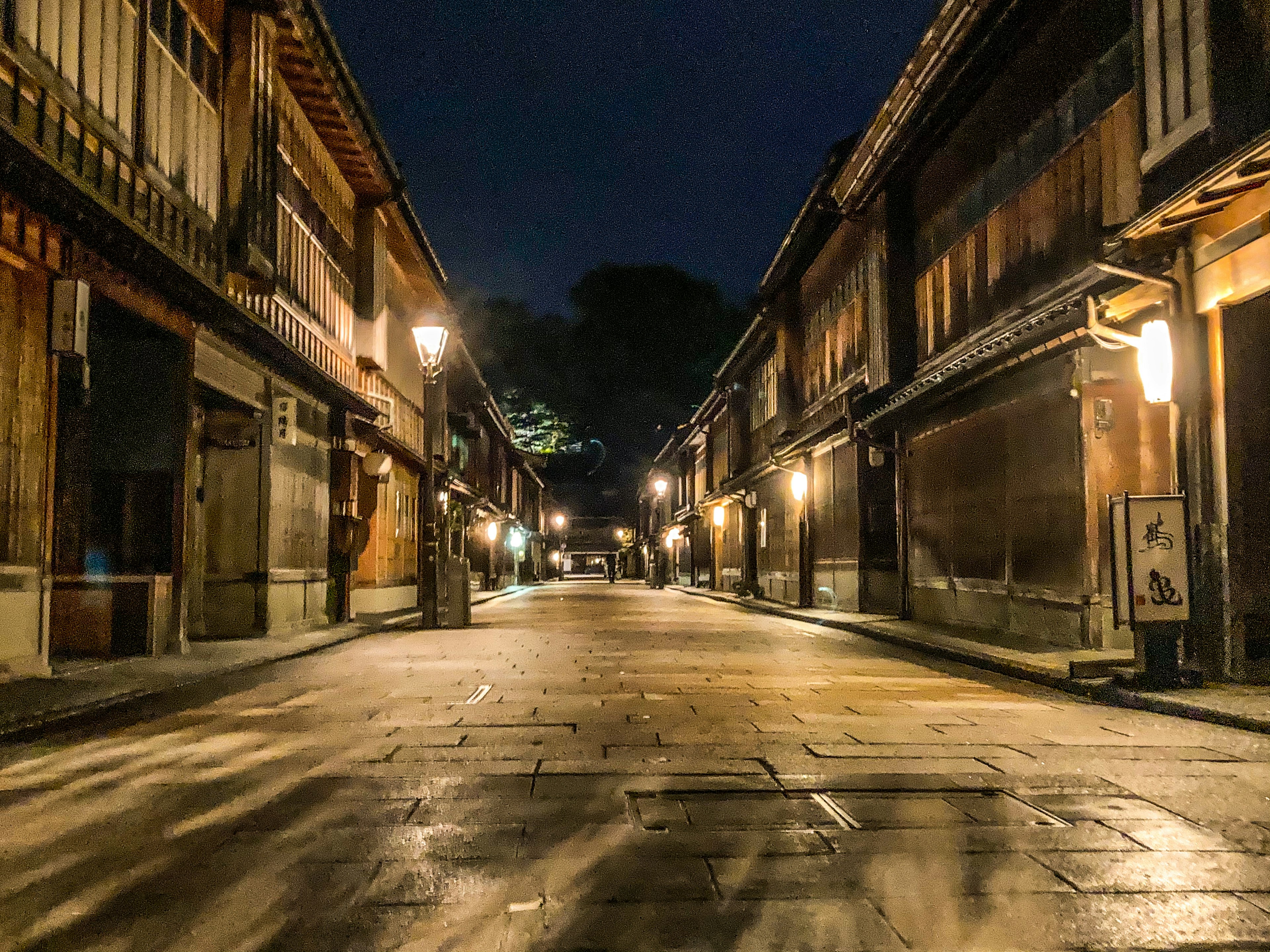 Jalan sepi di malam hari dengan bangunan kayu tradisional