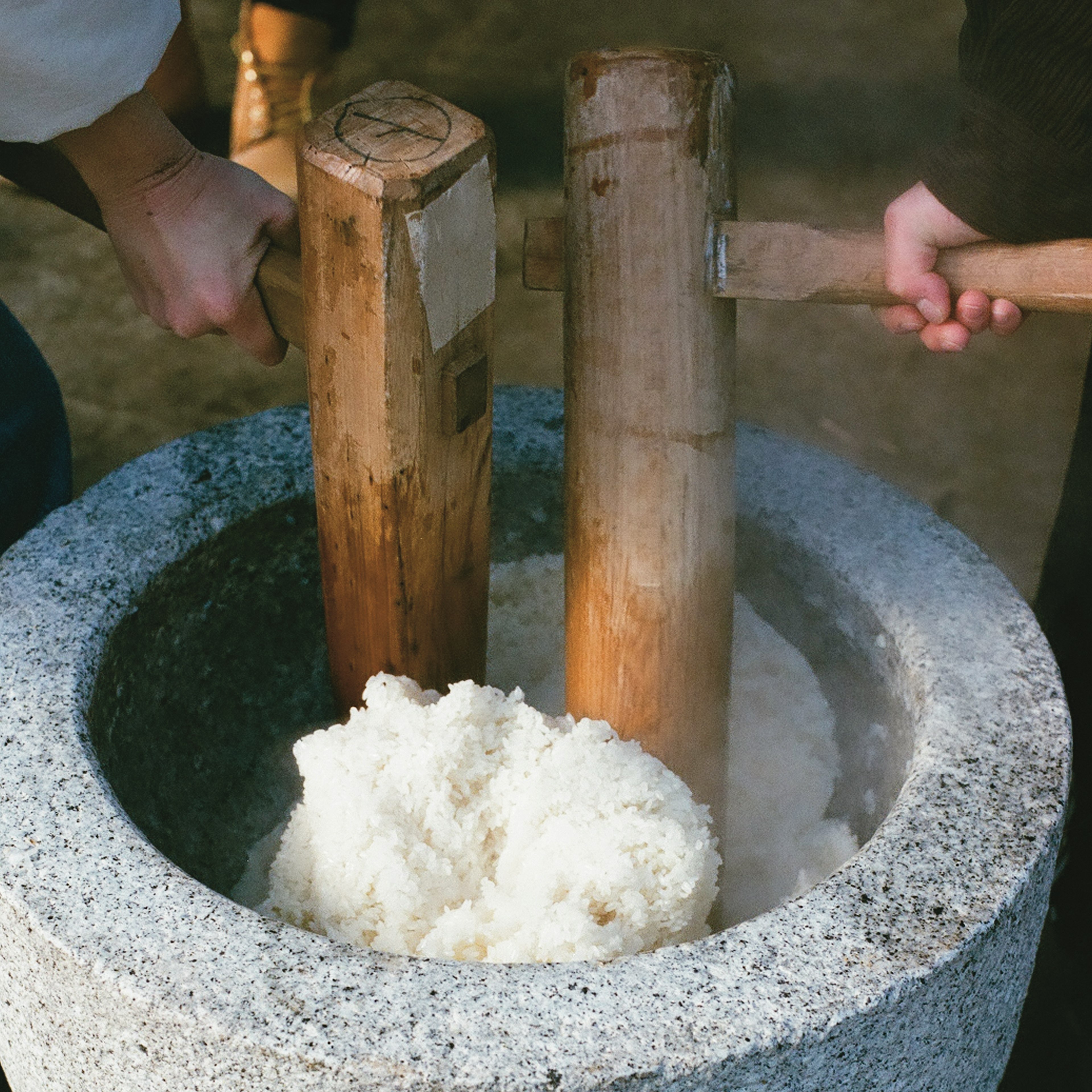 杵で餅をつく伝統的な作業が行われているシーン