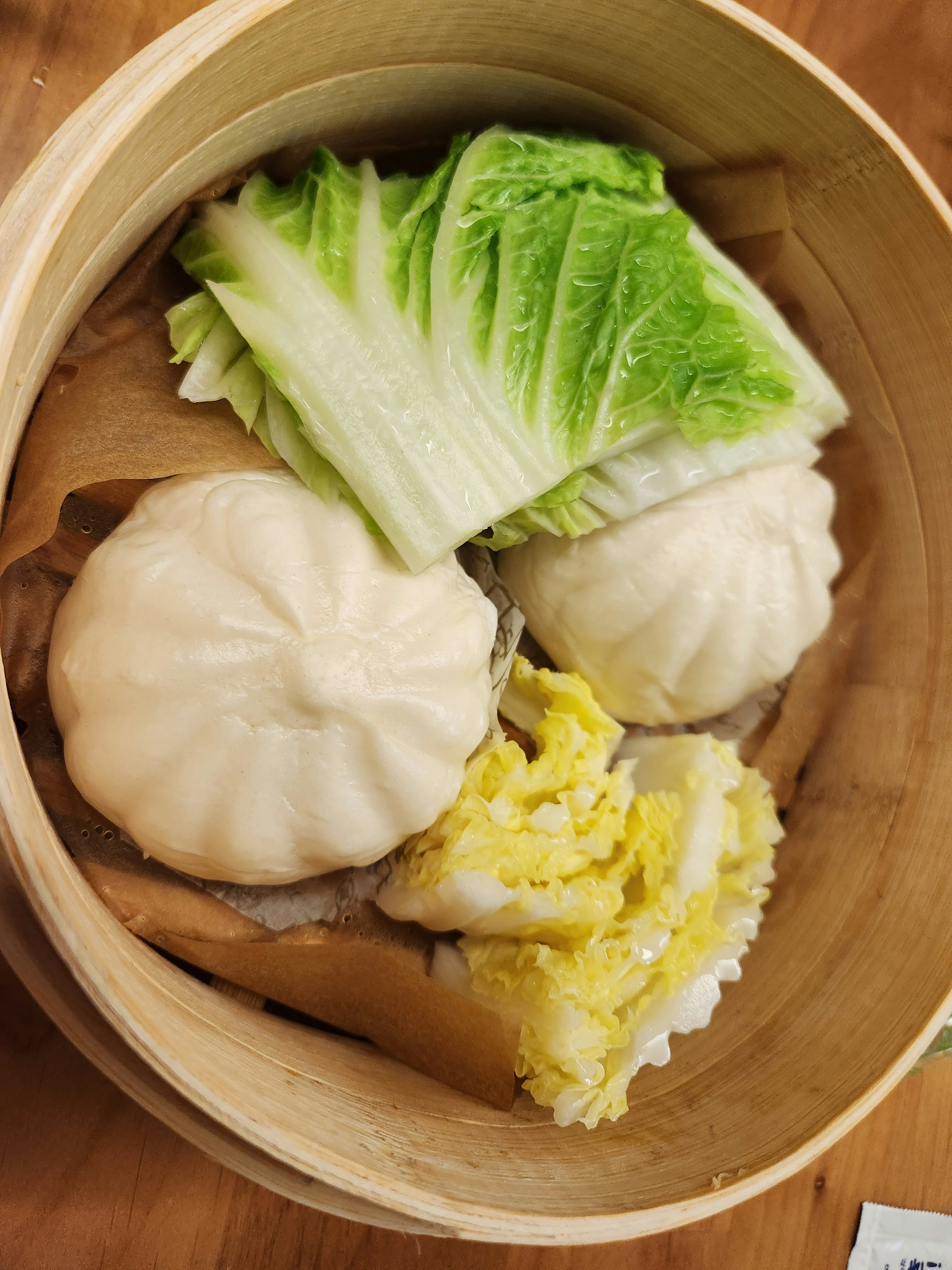 Steamed buns with cabbage and rice in a bamboo steamer