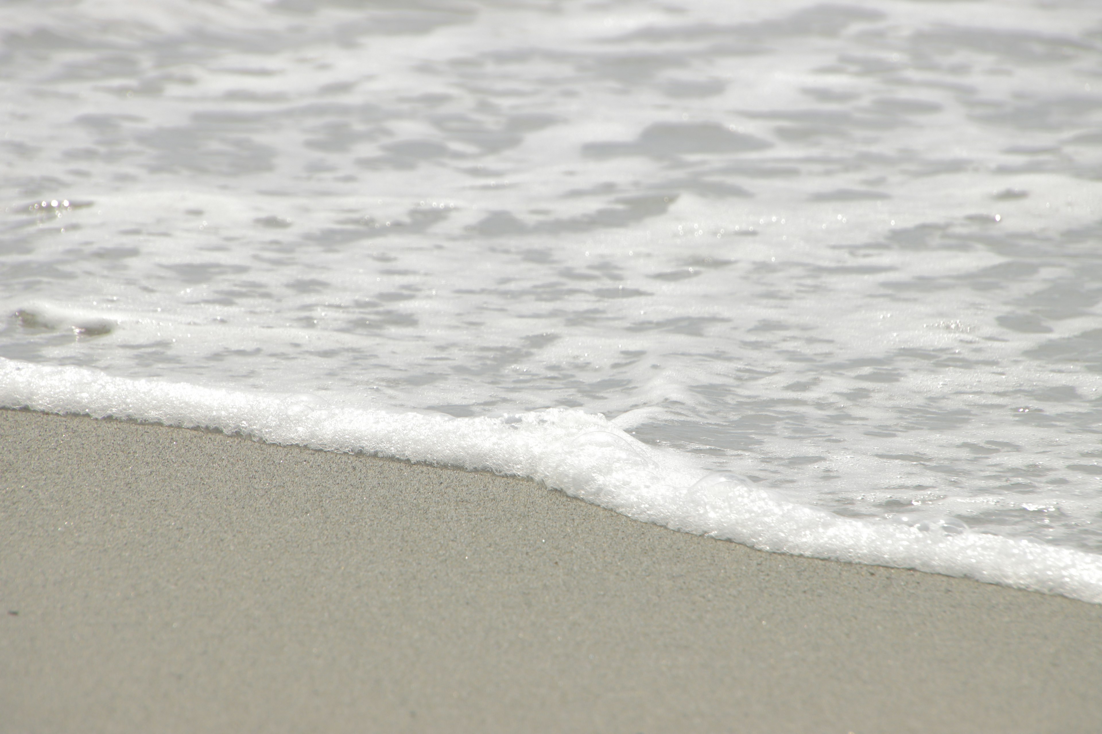 Waves gently lapping onto a sandy beach