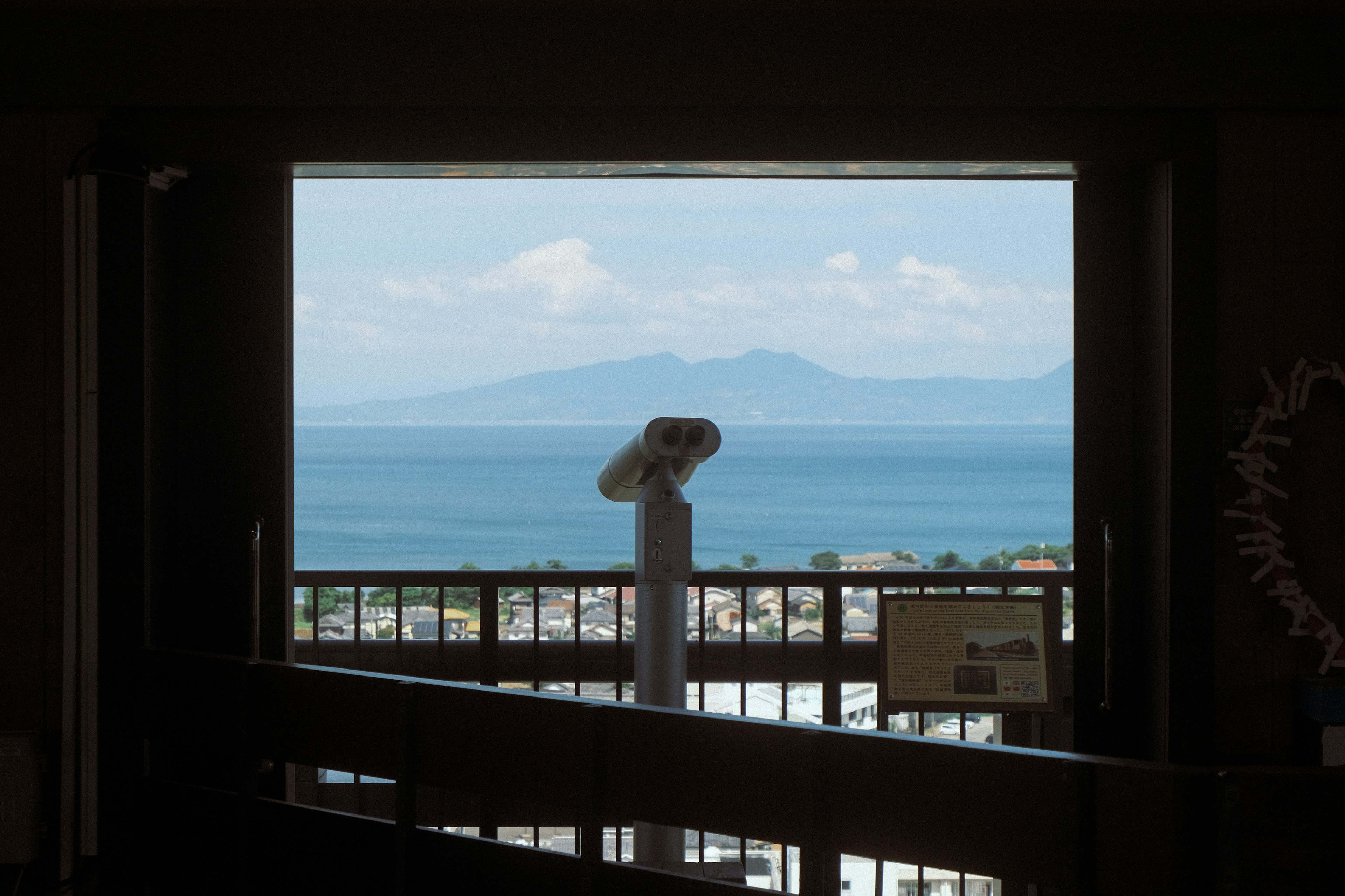 Vista escénica del mar azul y montañas a través de una ventana de observación