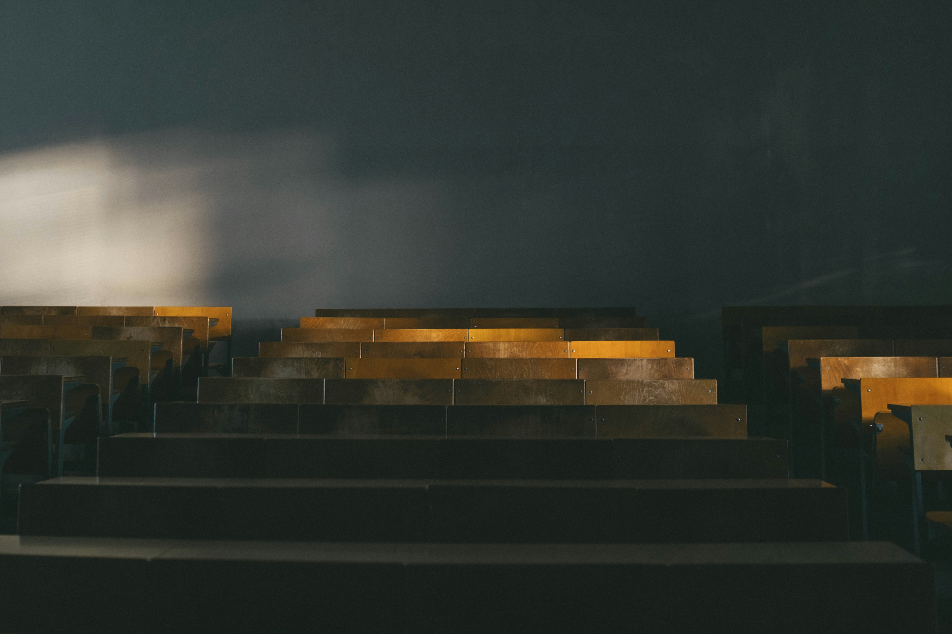 Contraste des bancs en bois et de la lumière sur un fond sombre