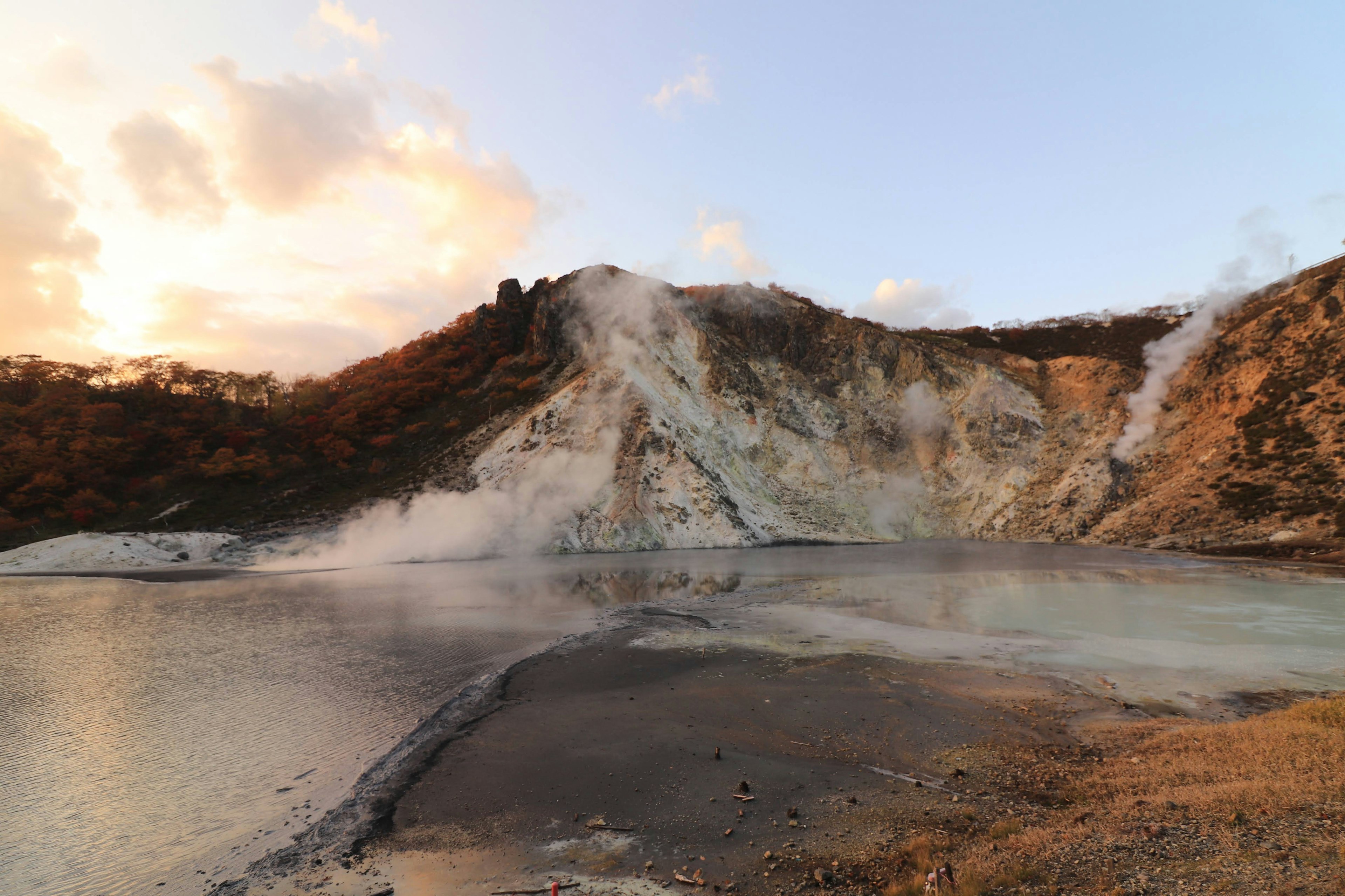 Paysage volcanique avec des sources chaudes illuminées par le coucher de soleil