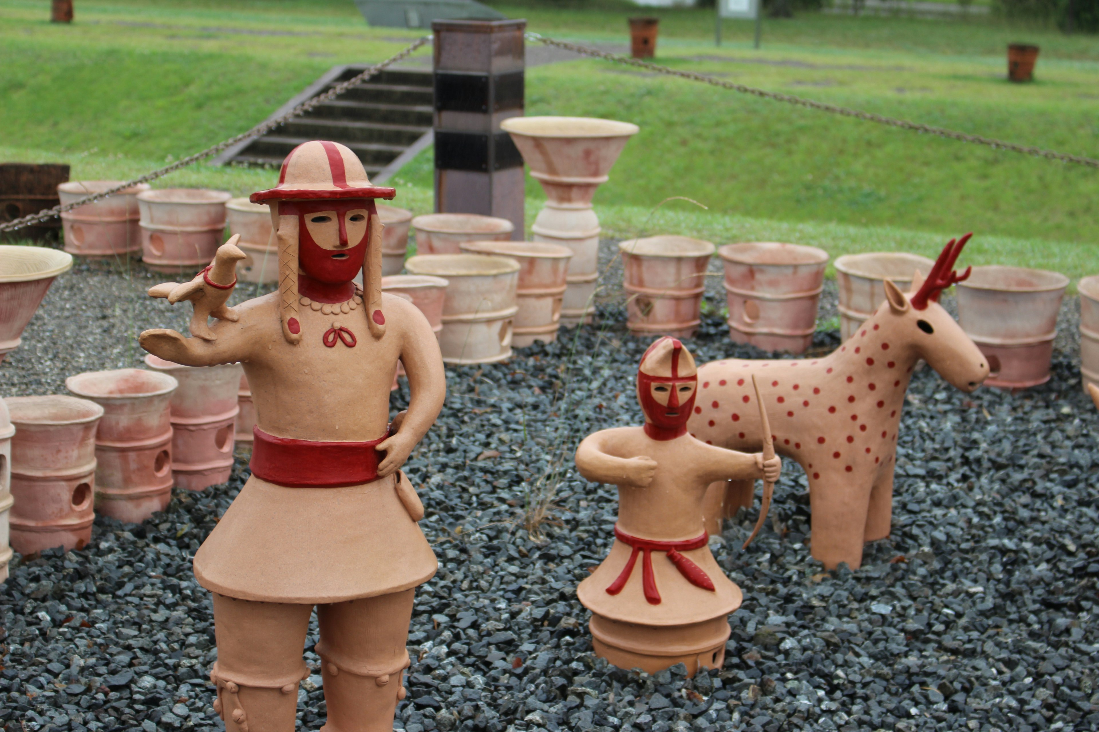 Terracotta figures of a warrior and a deer in a garden