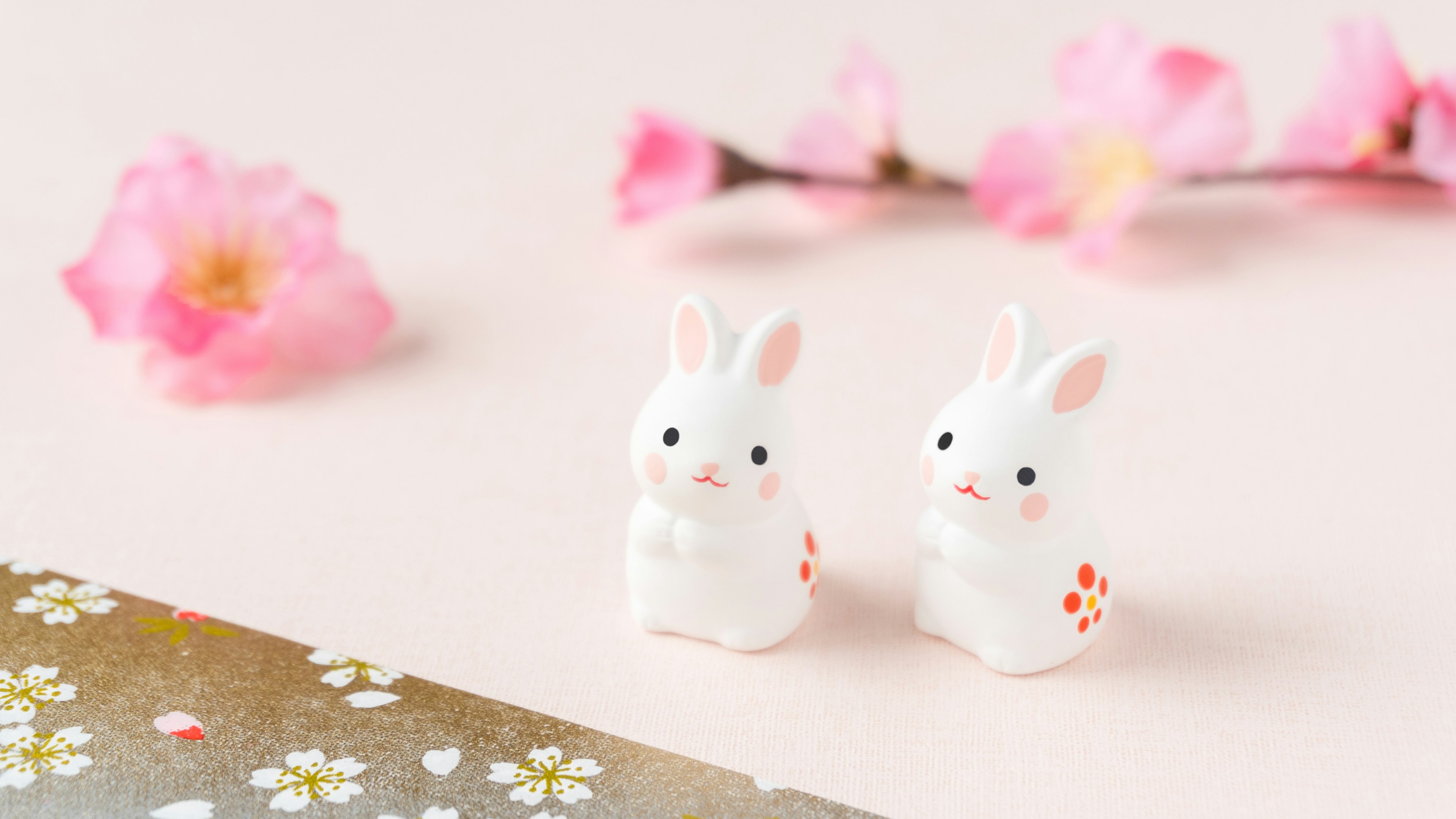 Scène mignonne avec des figurines de lapin blanc et des fleurs de cerisier