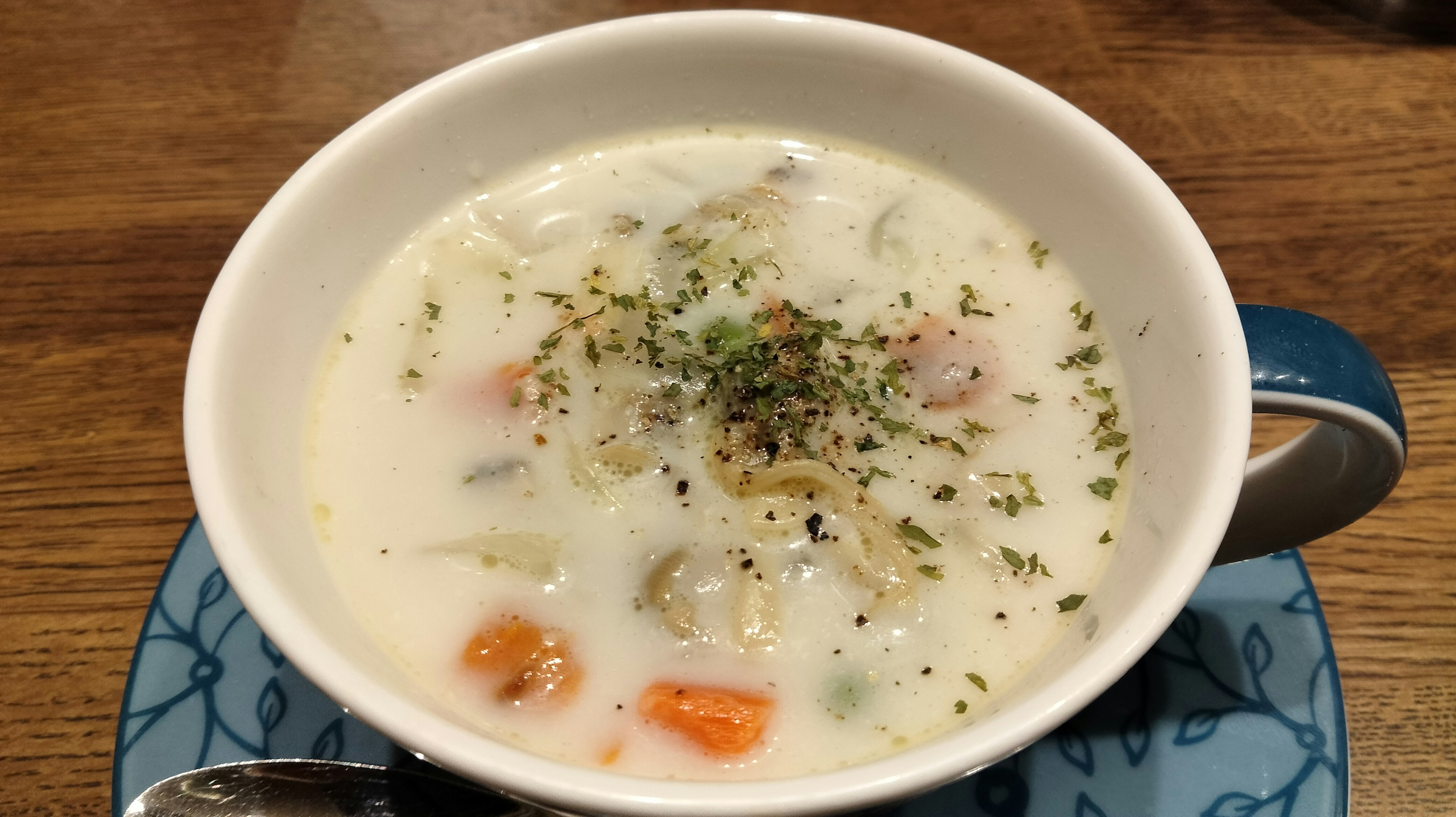 Soupe crémeuse dans un bol garnie de légumes et d'herbes