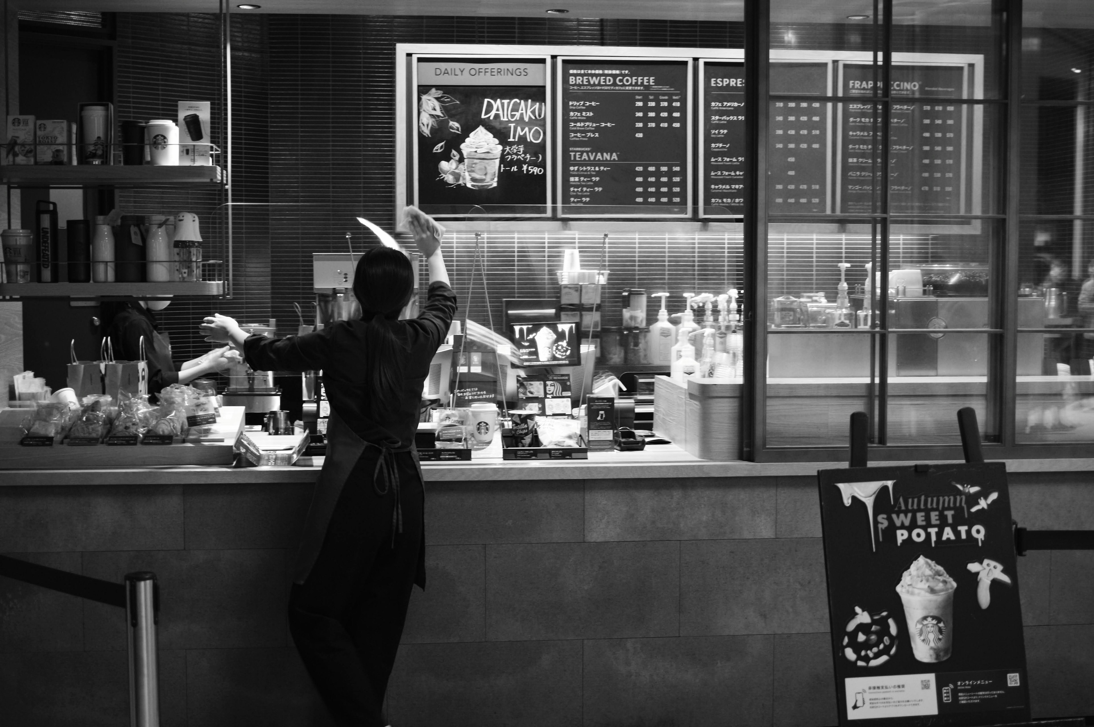 Personnel prenant des commandes au comptoir d'un restaurant dans un cadre monochrome