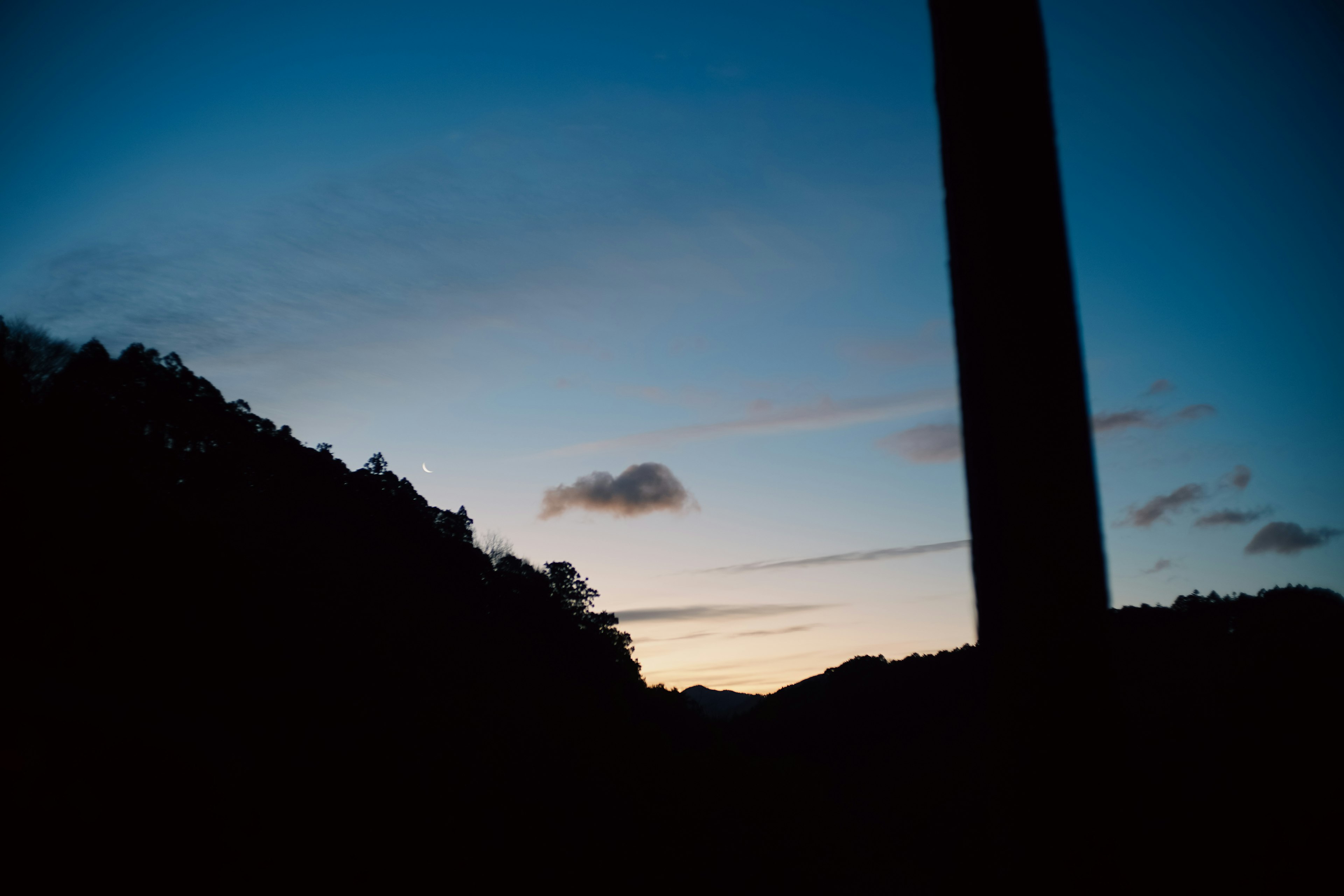 Silhouette gunung di latar belakang langit biru saat senja