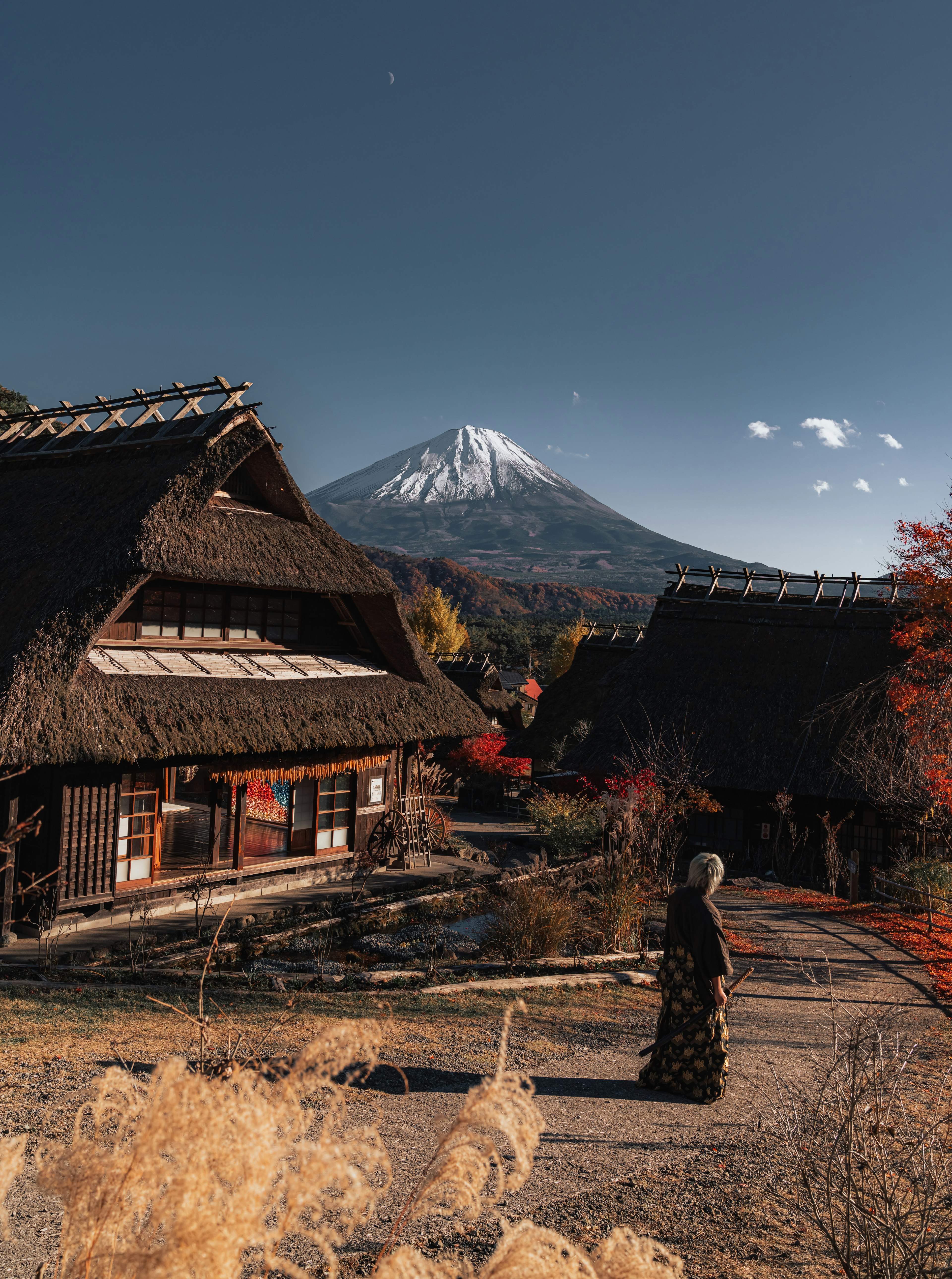 富士山を背景にした伝統的な日本の村の風景と秋の紅葉